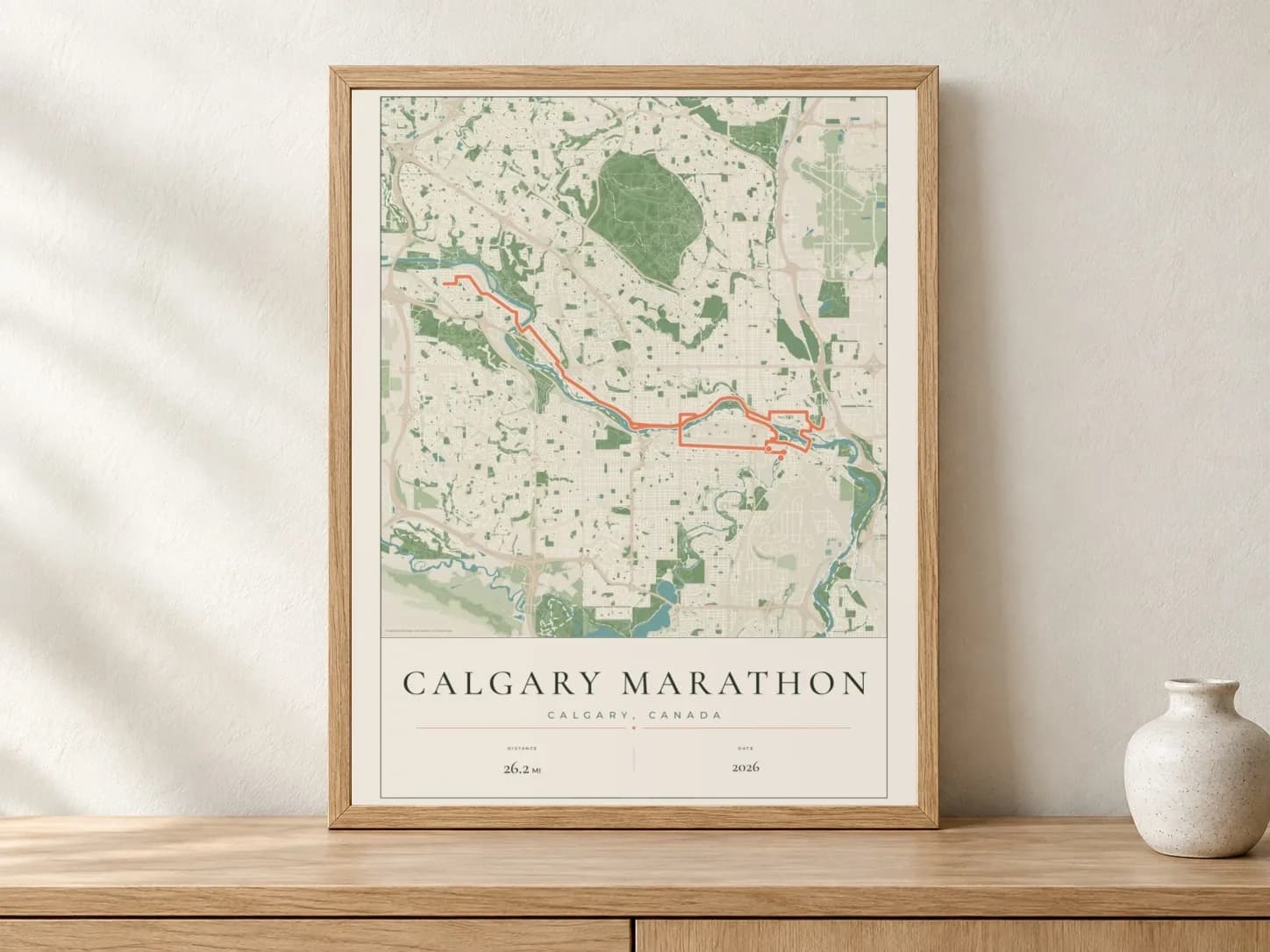 Calgary Marathon 2026 Parkland route print in a light oak frame on a console