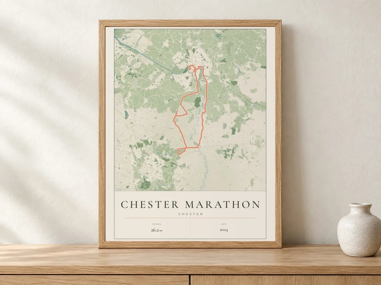 Chester Marathon 2024 Parkland route print in a light oak frame on a console