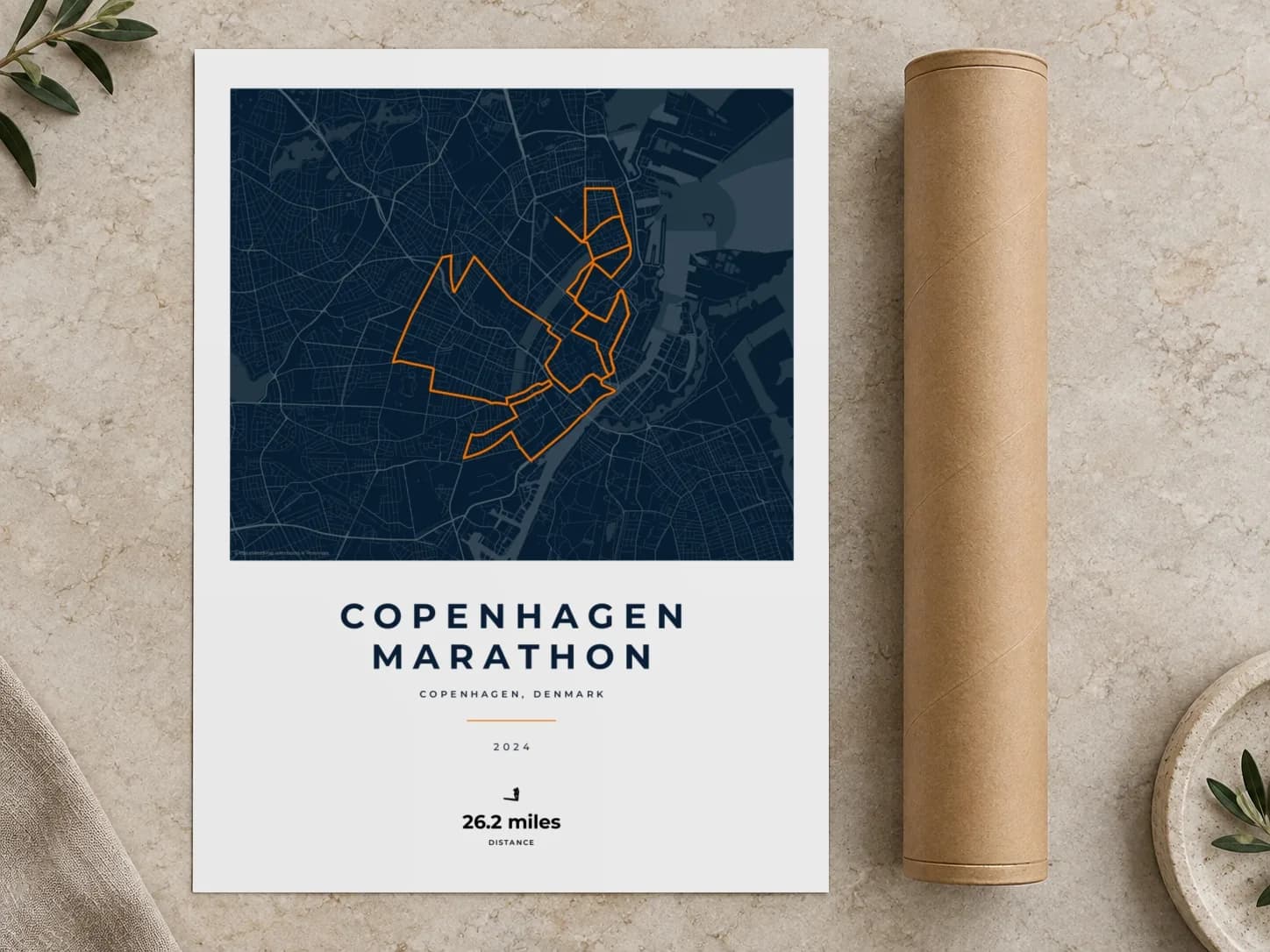 Cardboard postal tube beside a flat Copenhagen Marathon route print