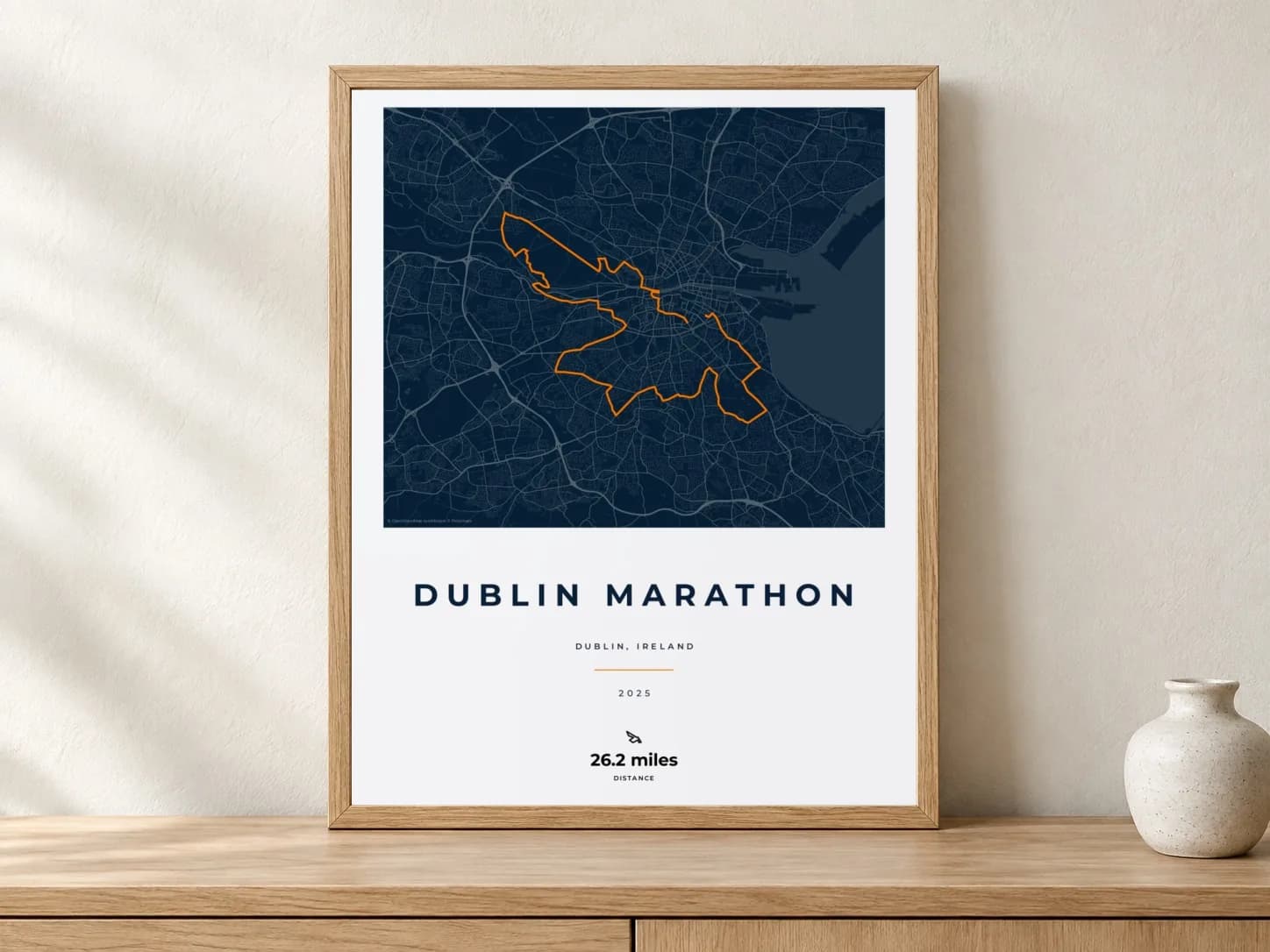 Dublin Marathon 2025 Race Blueprint route print in a light oak frame on a console