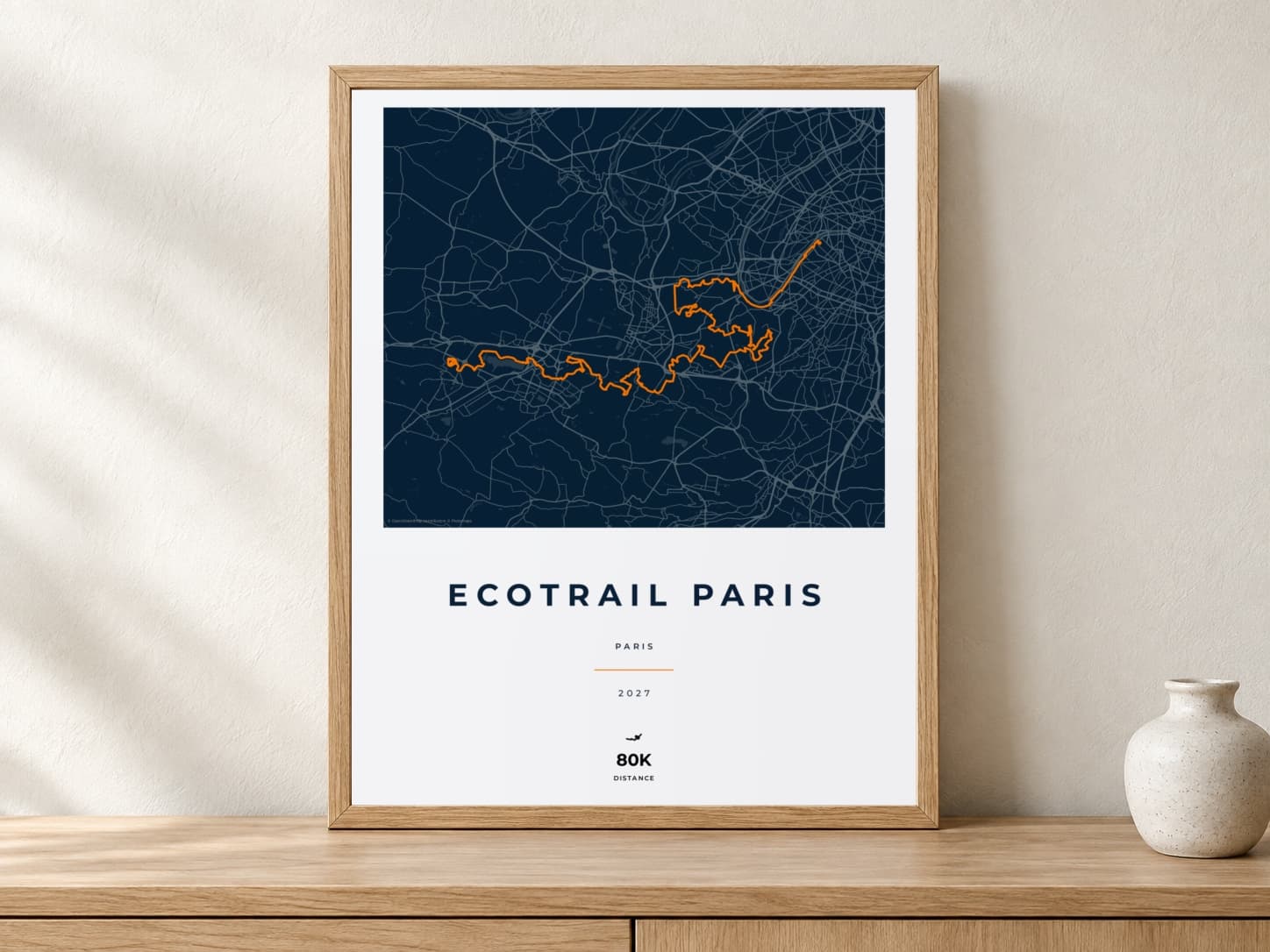 EcoTrail Paris 2027 Race Blueprint route print in a light oak frame on a console