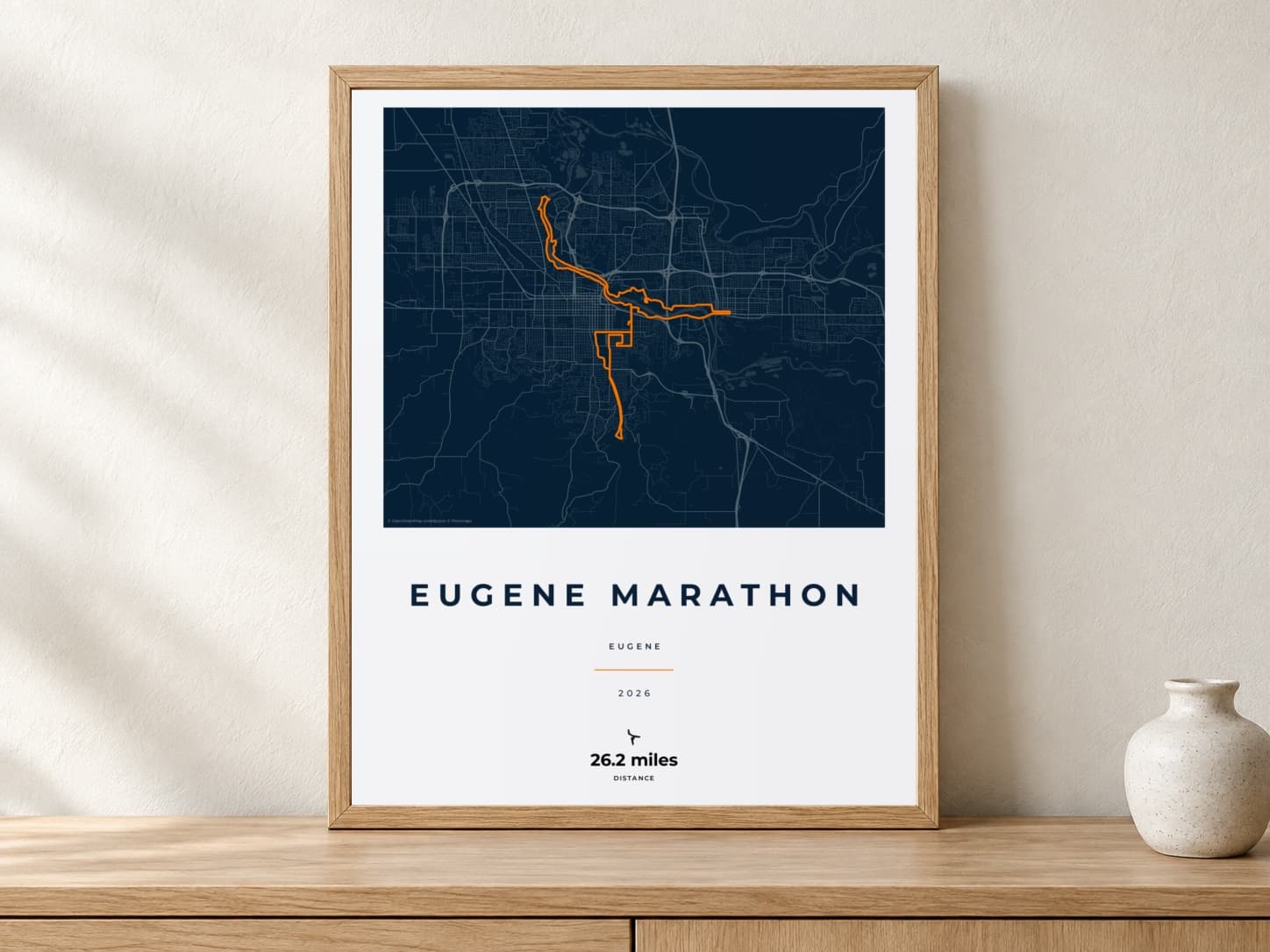 Eugene Marathon 2026 Race Blueprint route print in a light oak frame on a console