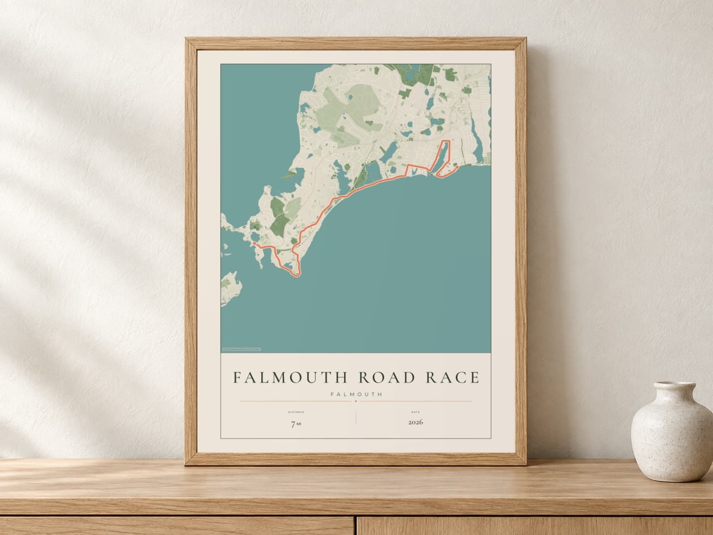 Falmouth Road Race 2026 Parkland route print in a light oak frame on a console