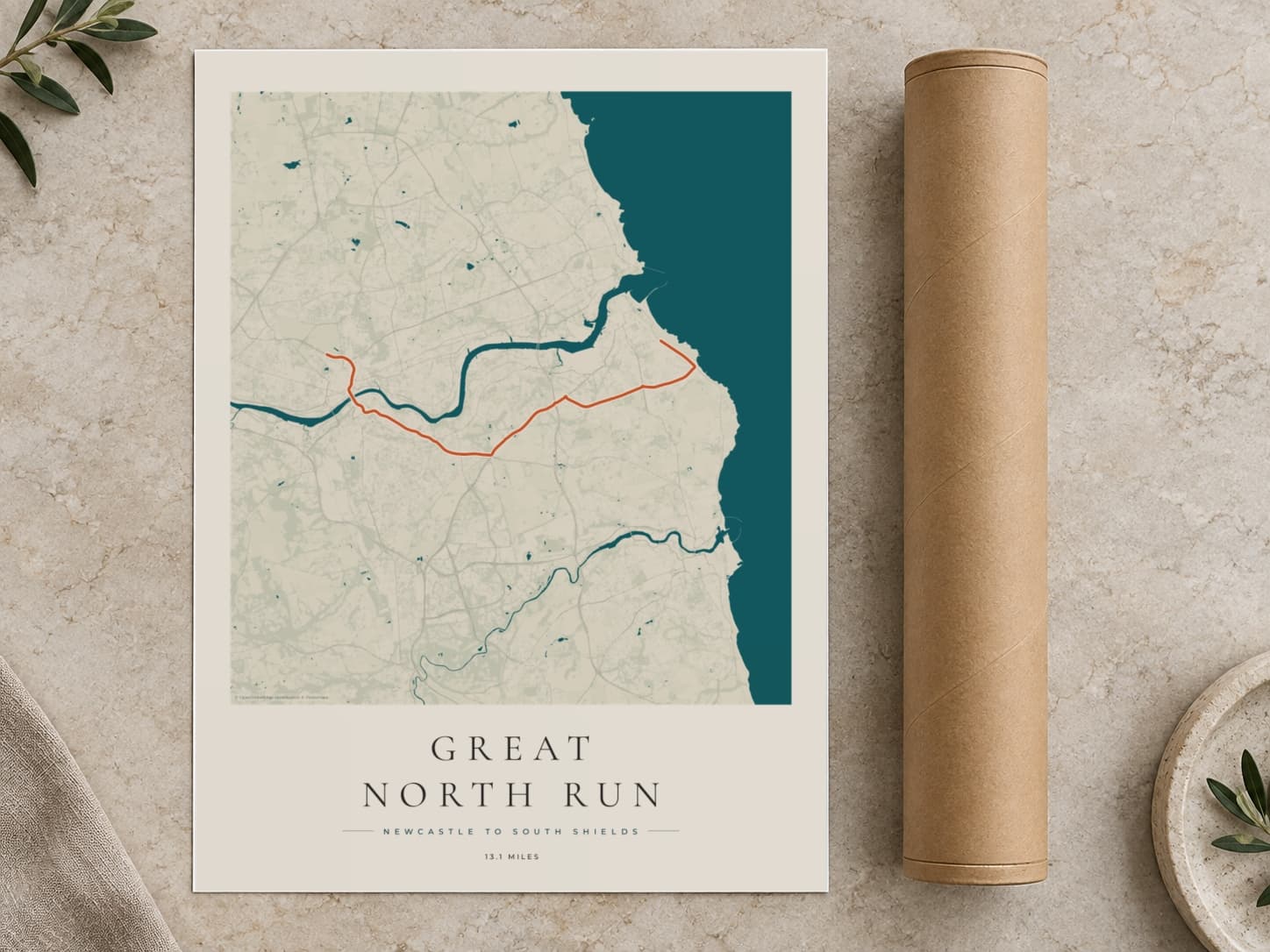 Cardboard postal tube beside a flat Great North Run route print