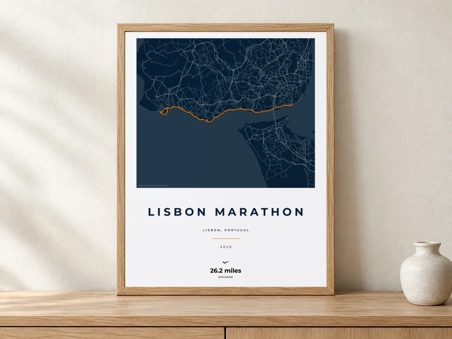 Lisbon Marathon 2025 Race Blueprint route print in a light oak frame on a console
