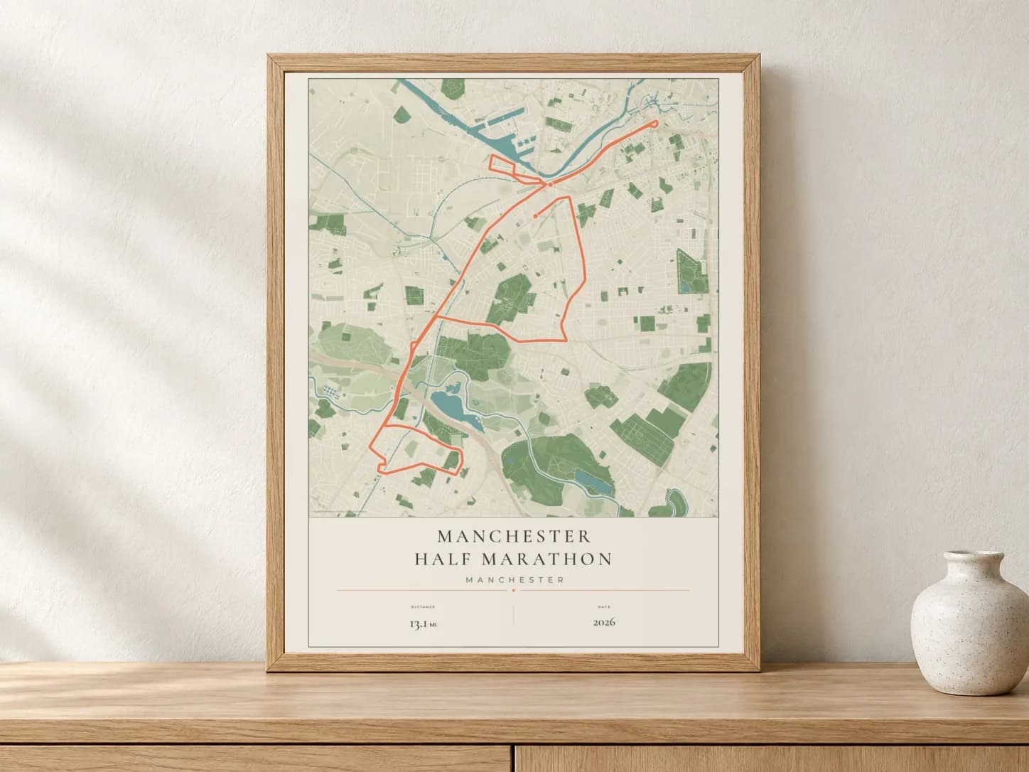 Manchester Half Marathon 2026 Parkland route print in a light oak frame on a console