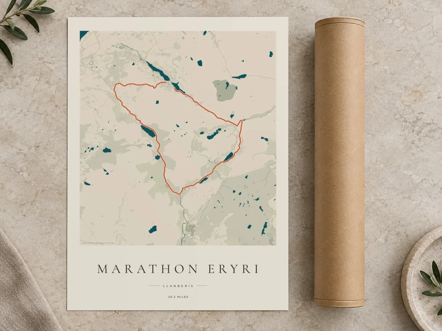 Cardboard postal tube beside a flat Marathon Eryri route print