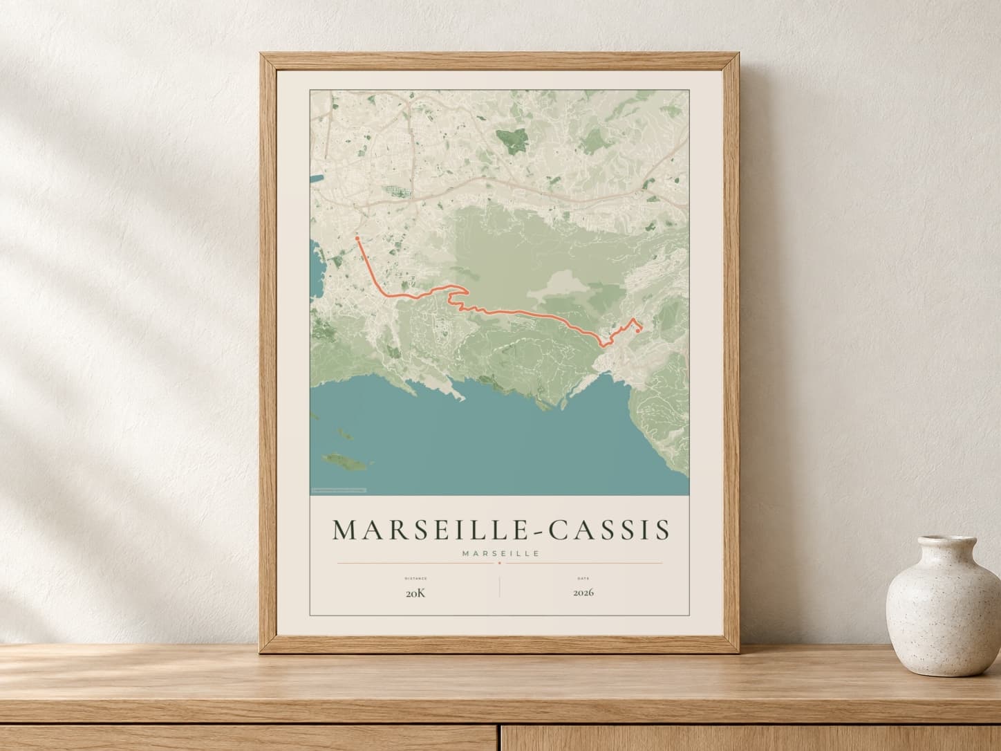 Marseille-Cassis 2026 Parkland route print in a light oak frame on a console