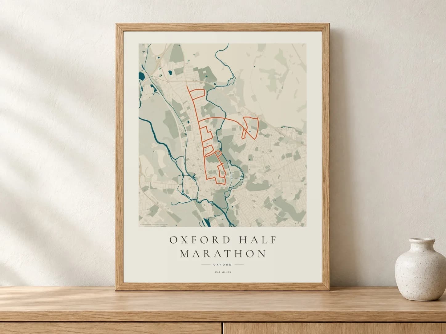 Oxford Half Marathon Coastal Atlas route print in a light oak frame on a console