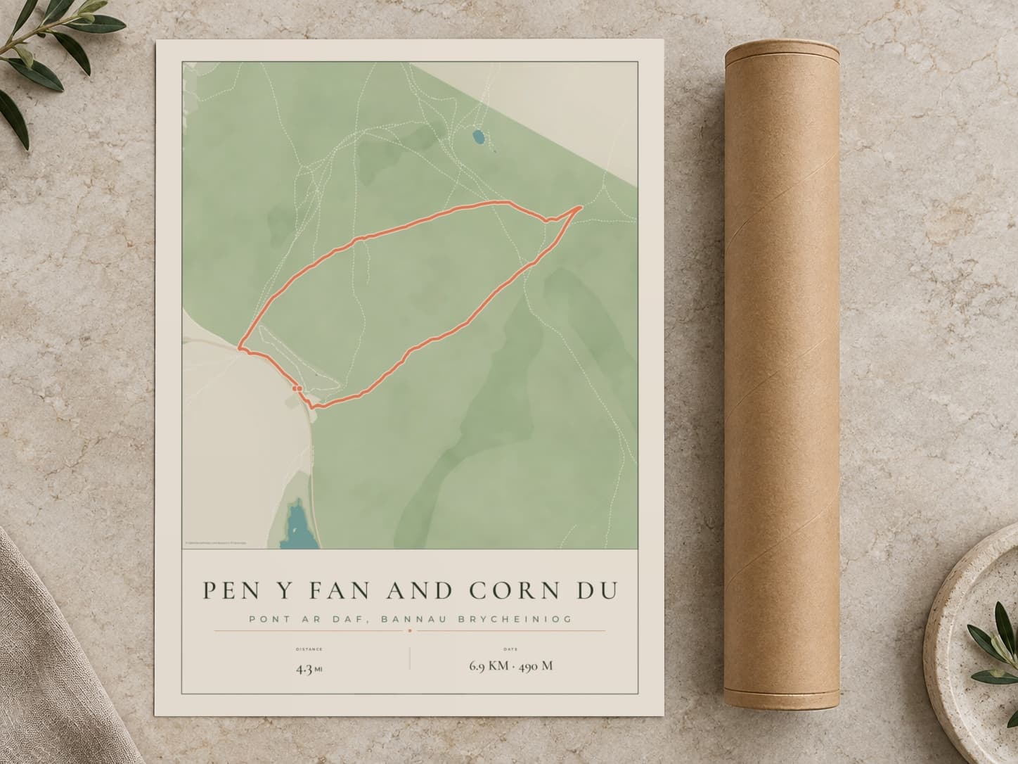 Cardboard postal tube beside a flat Pen y Fan route print