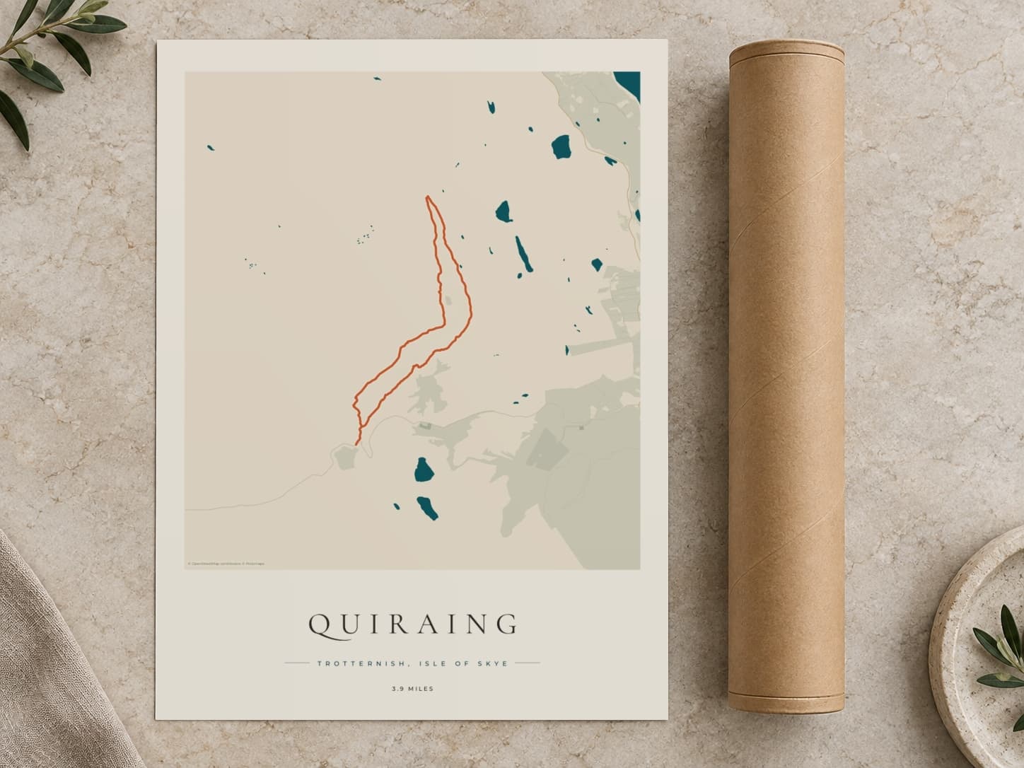 Cardboard postal tube beside a flat Quiraing route print