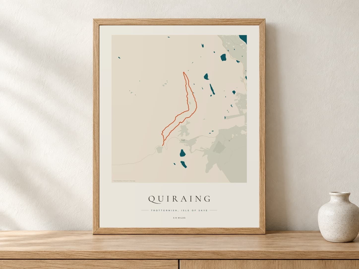 Quiraing Coastal Atlas route print in a light oak frame on a console