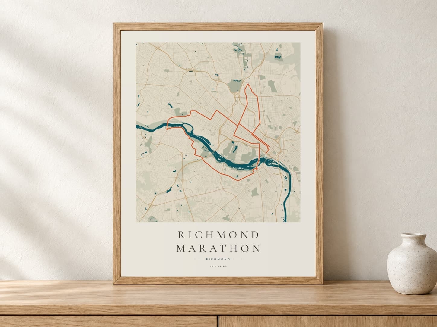 Richmond Marathon 2026 Coastal Atlas route print in a light oak frame on a console