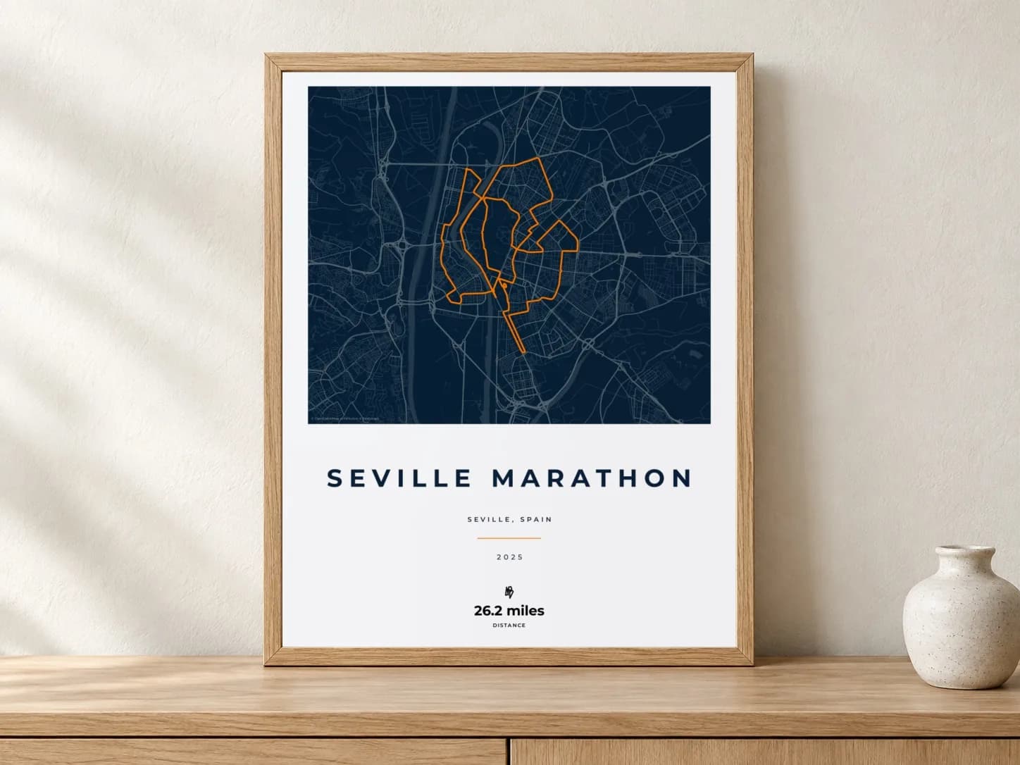 Seville Marathon 2025 Race Blueprint route print in a light oak frame on a console
