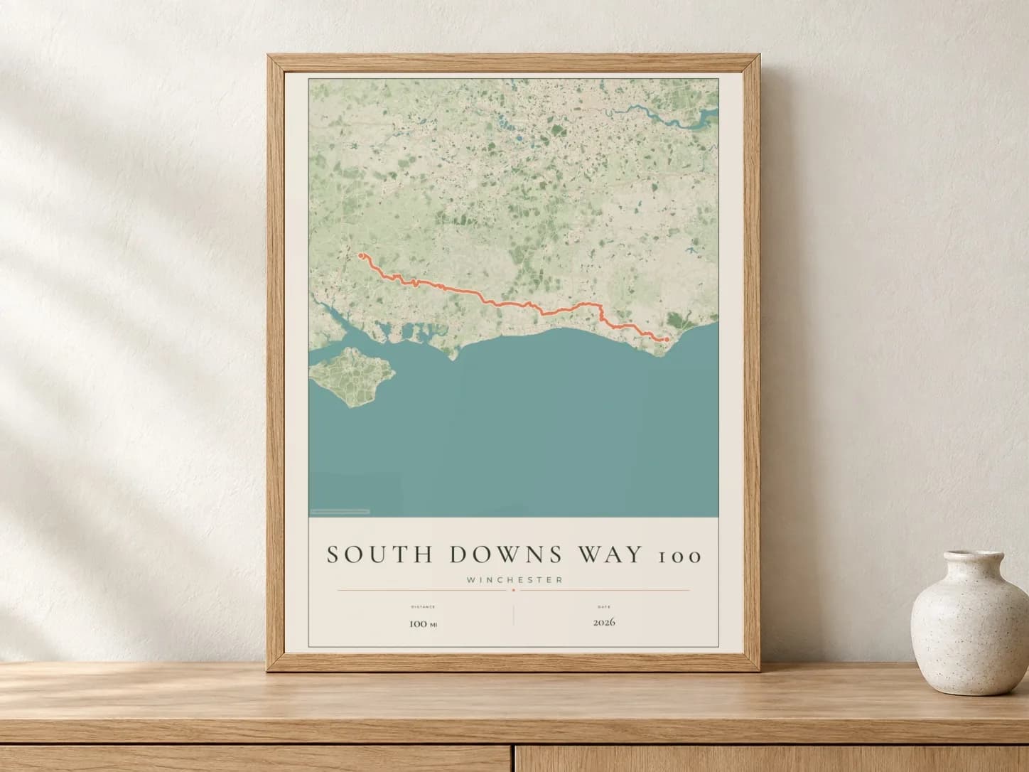 South Downs Way 100 2026 Parkland route print in a light oak frame on a console