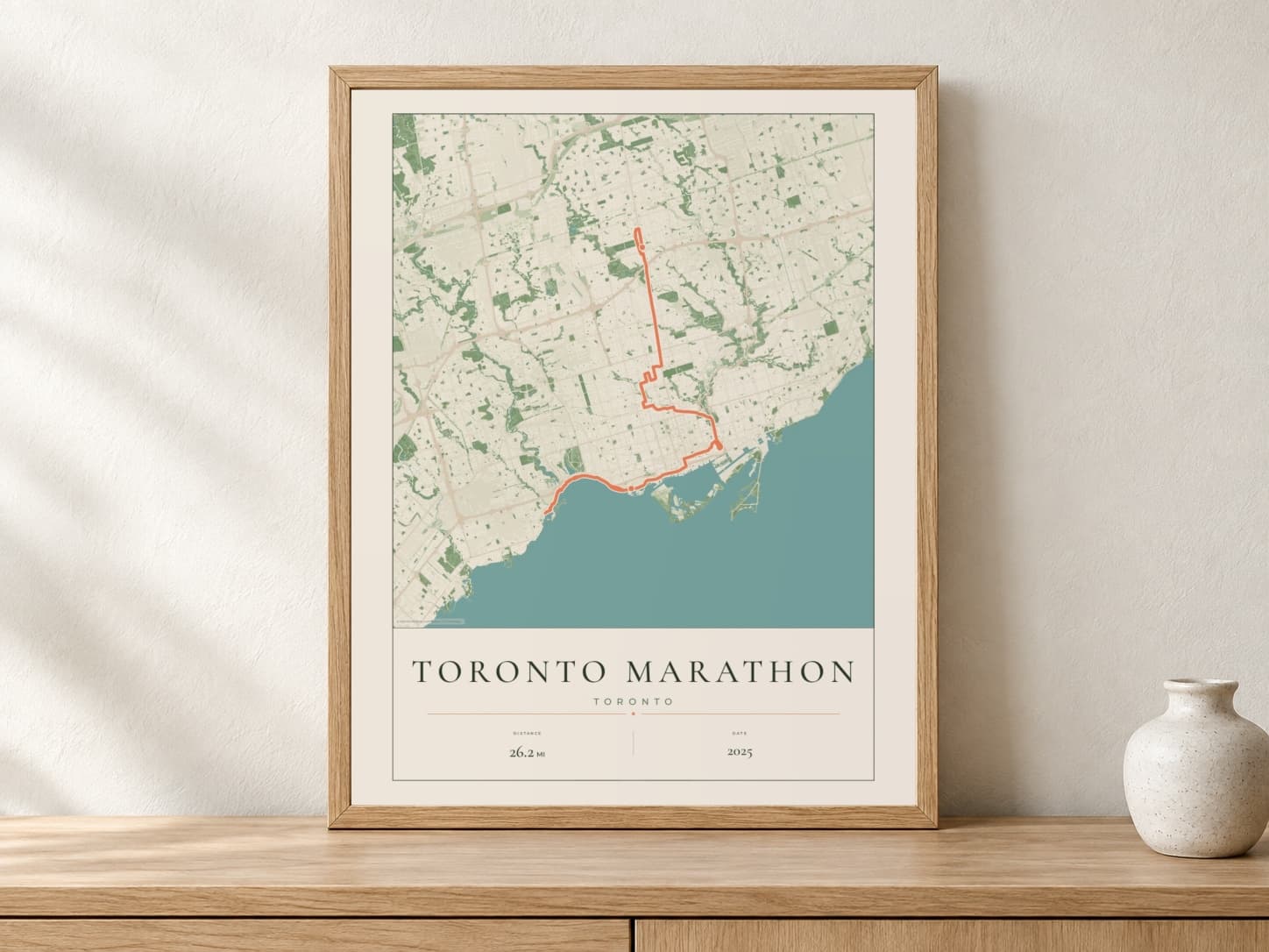 Toronto Marathon 2025 Parkland route print in a light oak frame on a console