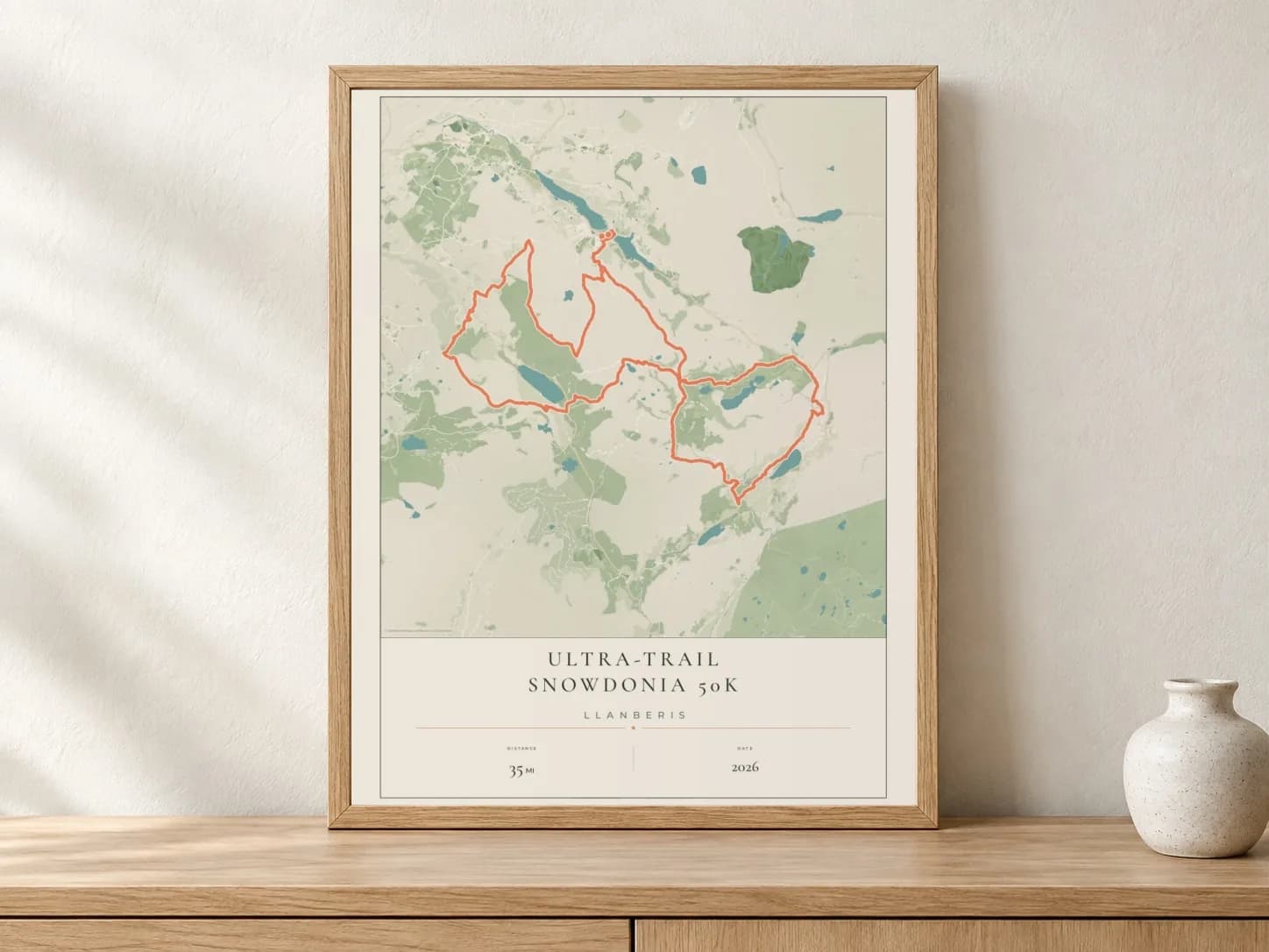 Ultra-Trail Snowdonia 50K 2026 Parkland route print in a light oak frame on a console