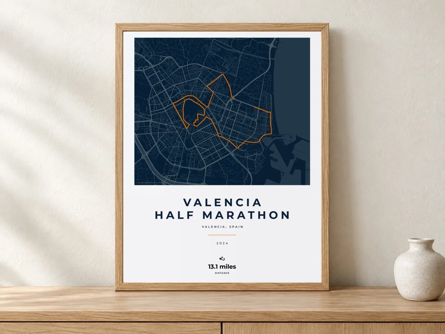 Valencia Half Marathon 2024 Race Blueprint route print in a light oak frame on a console