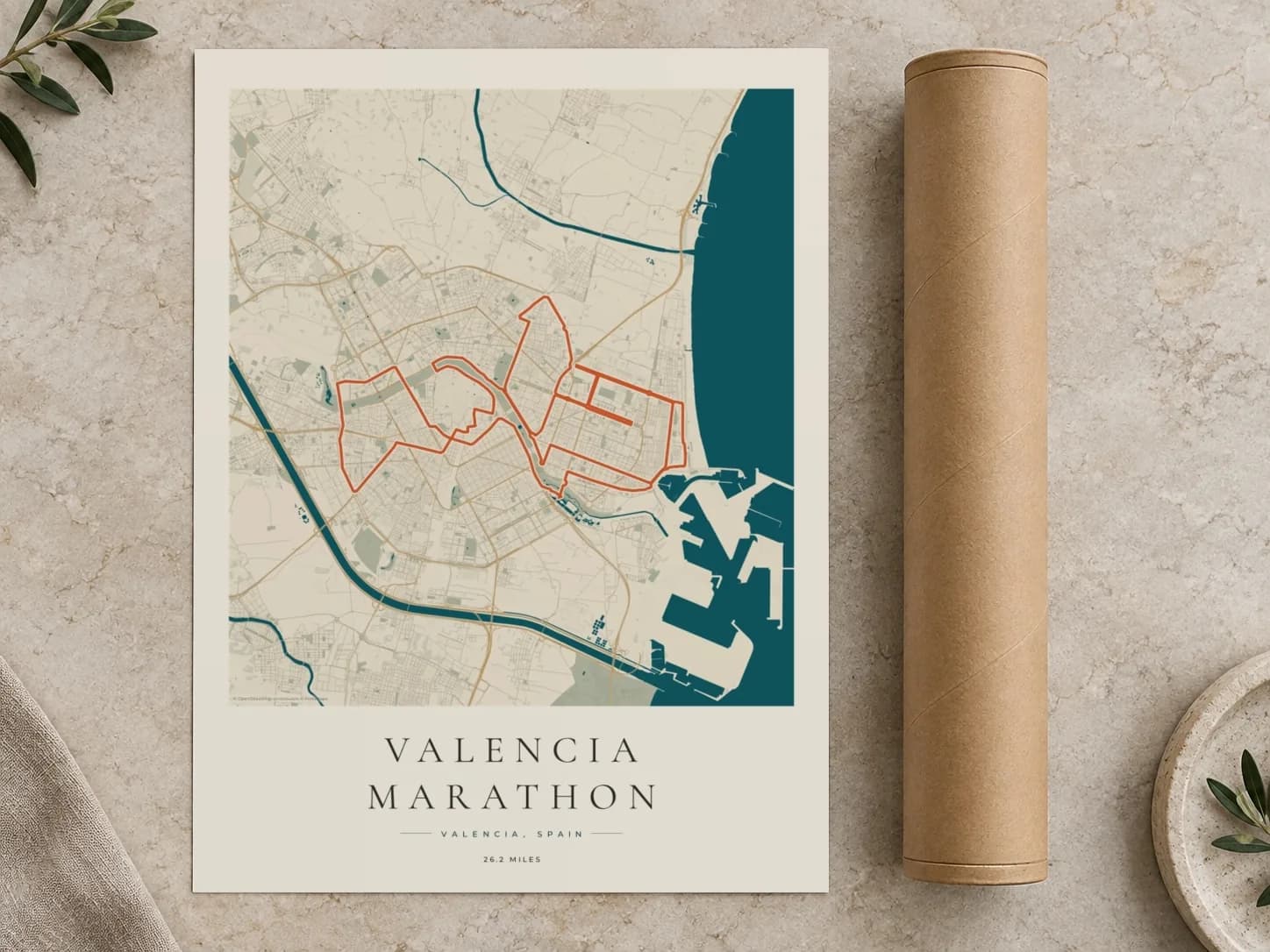 Cardboard postal tube beside a flat Valencia Marathon route print