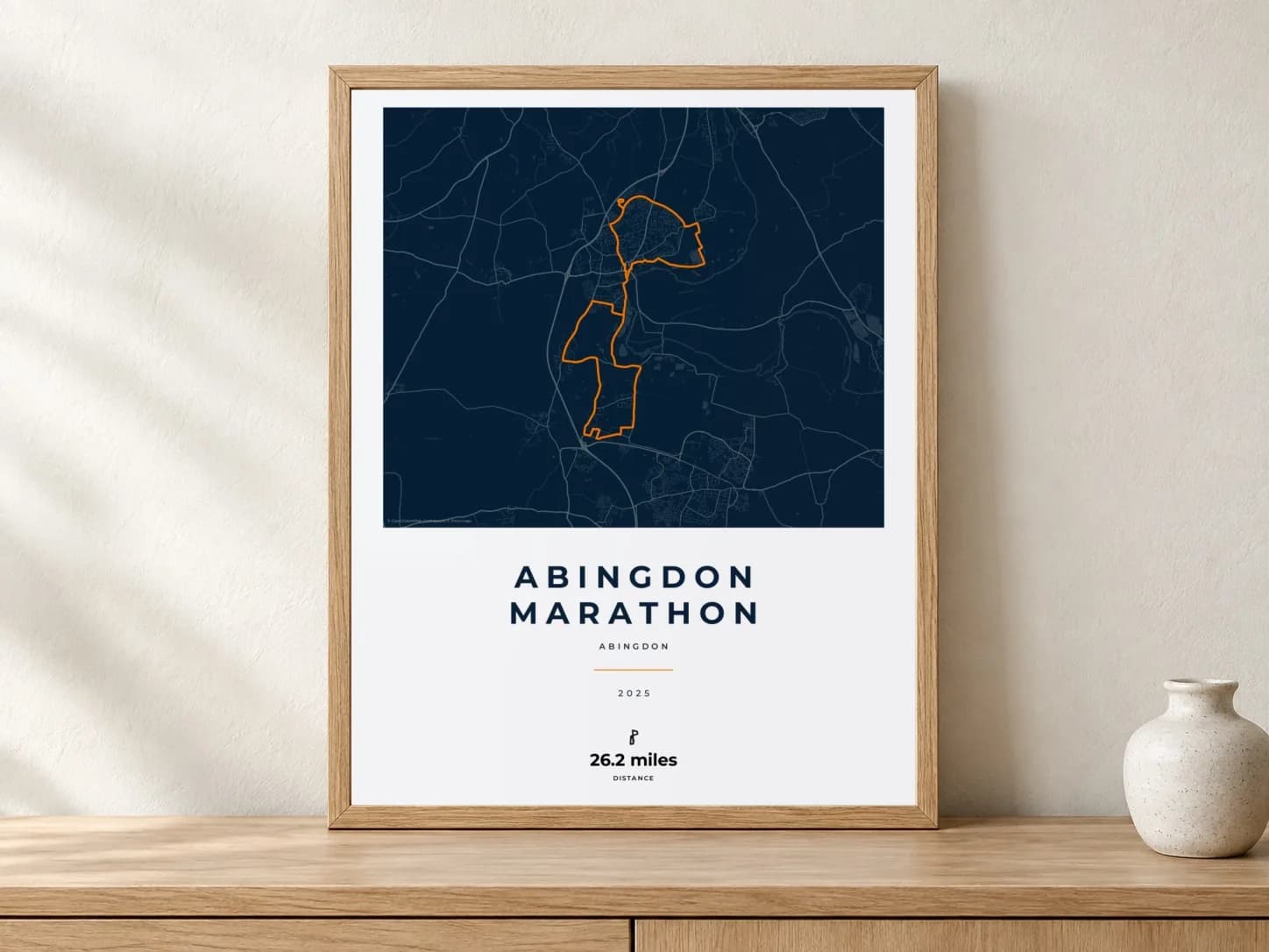 Abingdon Marathon 2025 Race Blueprint route print in a light oak frame on a console