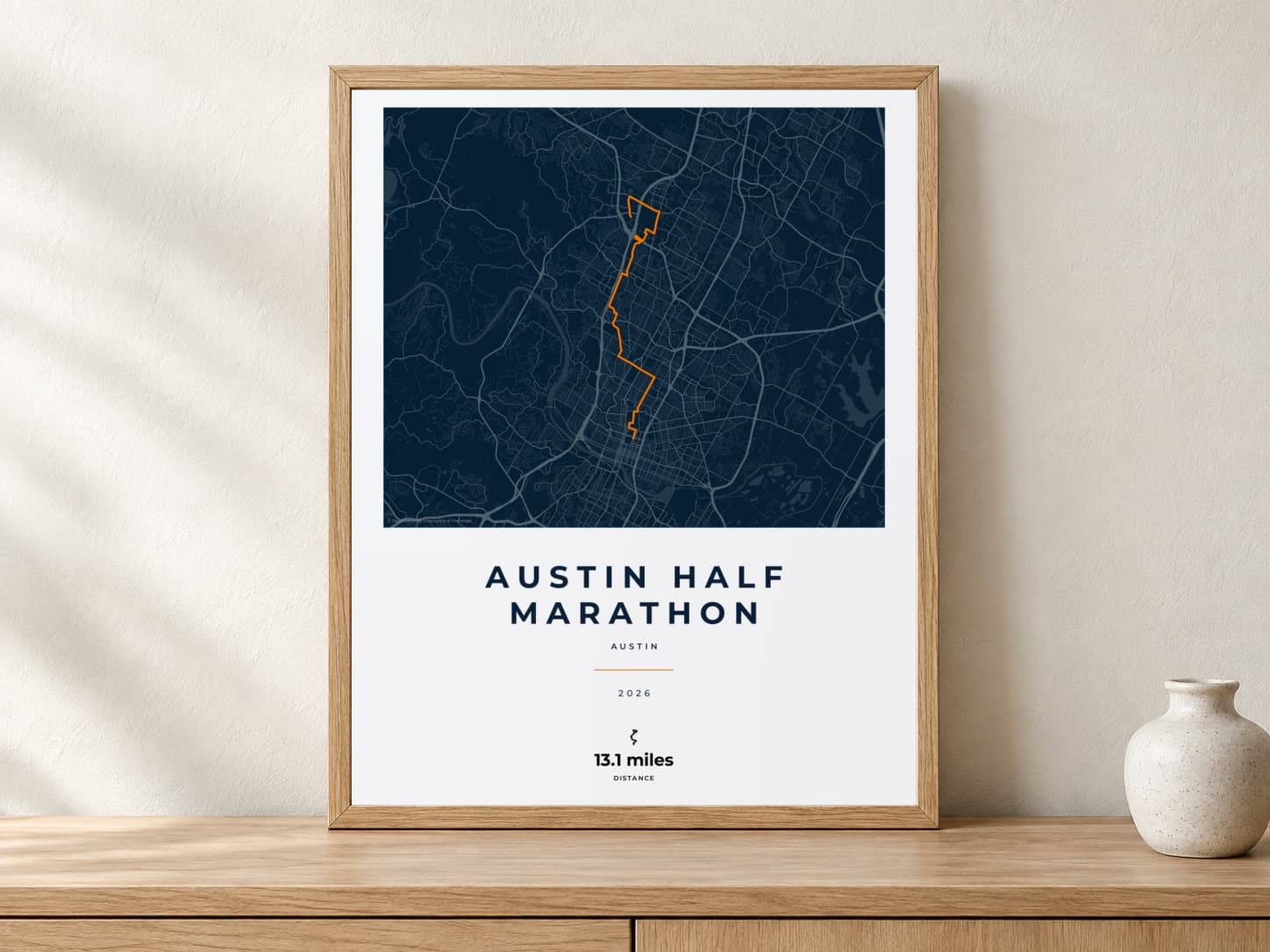 Austin Half Marathon 2026 Race Blueprint route print in a light oak frame on a console