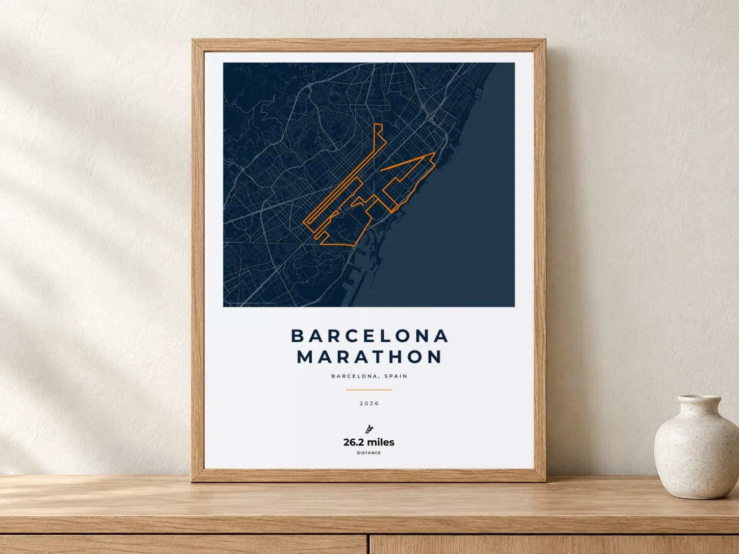 Barcelona Marathon 2026 Race Blueprint route print in a light oak frame on a console