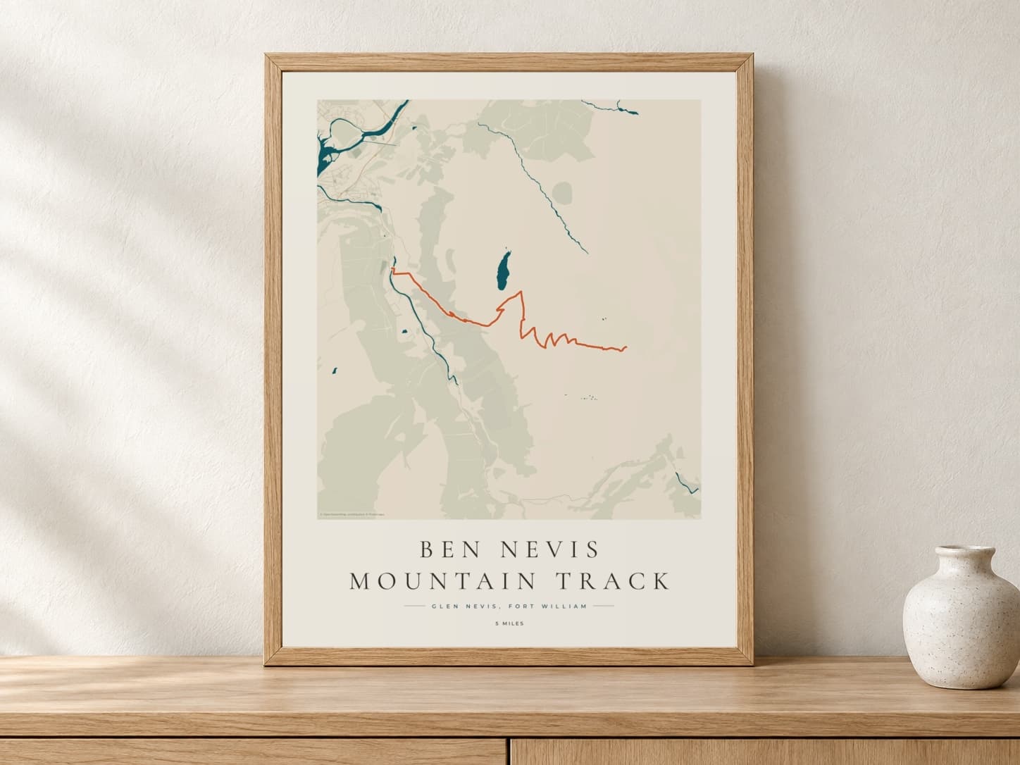 Ben Nevis Coastal Atlas route print in a light oak frame on a console