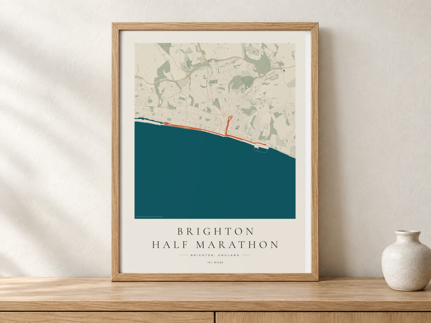 Brighton Half Marathon 2025 Coastal Atlas route print in a warm framed display scene