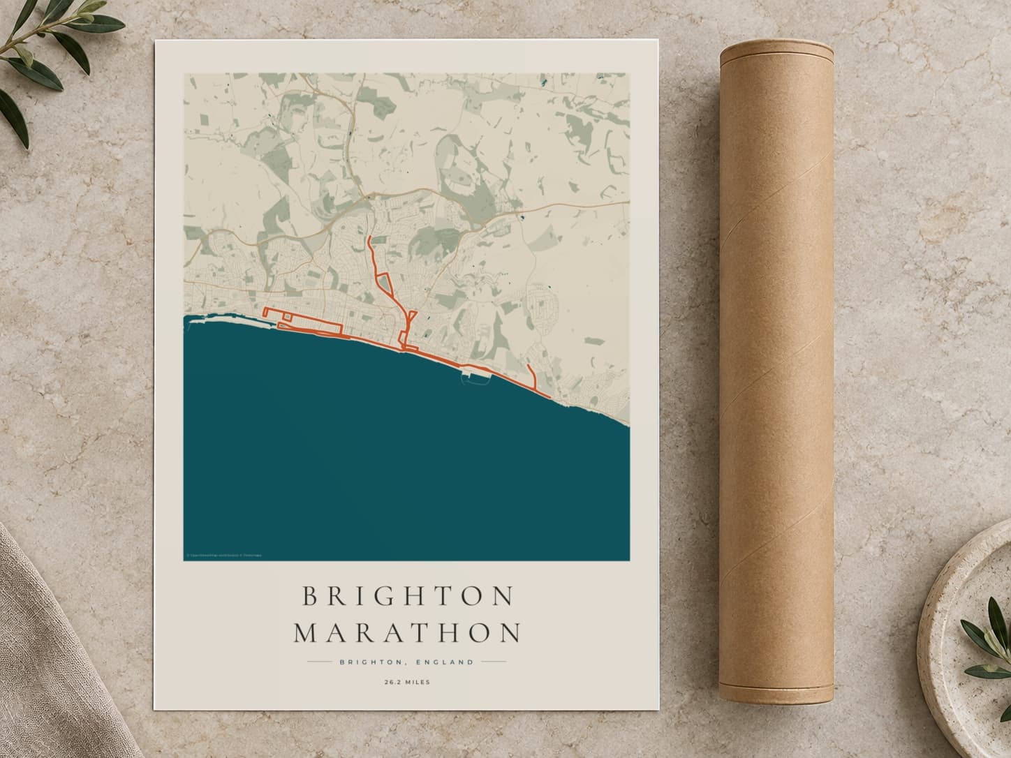 Cardboard postal tube beside a flat Brighton Marathon route print