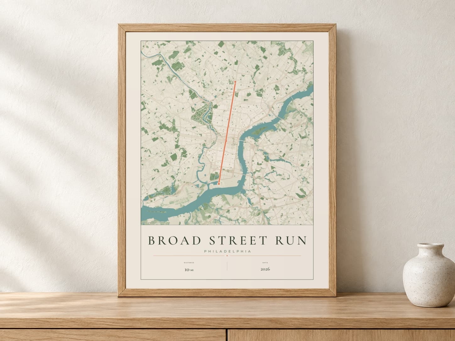 Broad Street Run 2026 Parkland route print in a light oak frame on a console