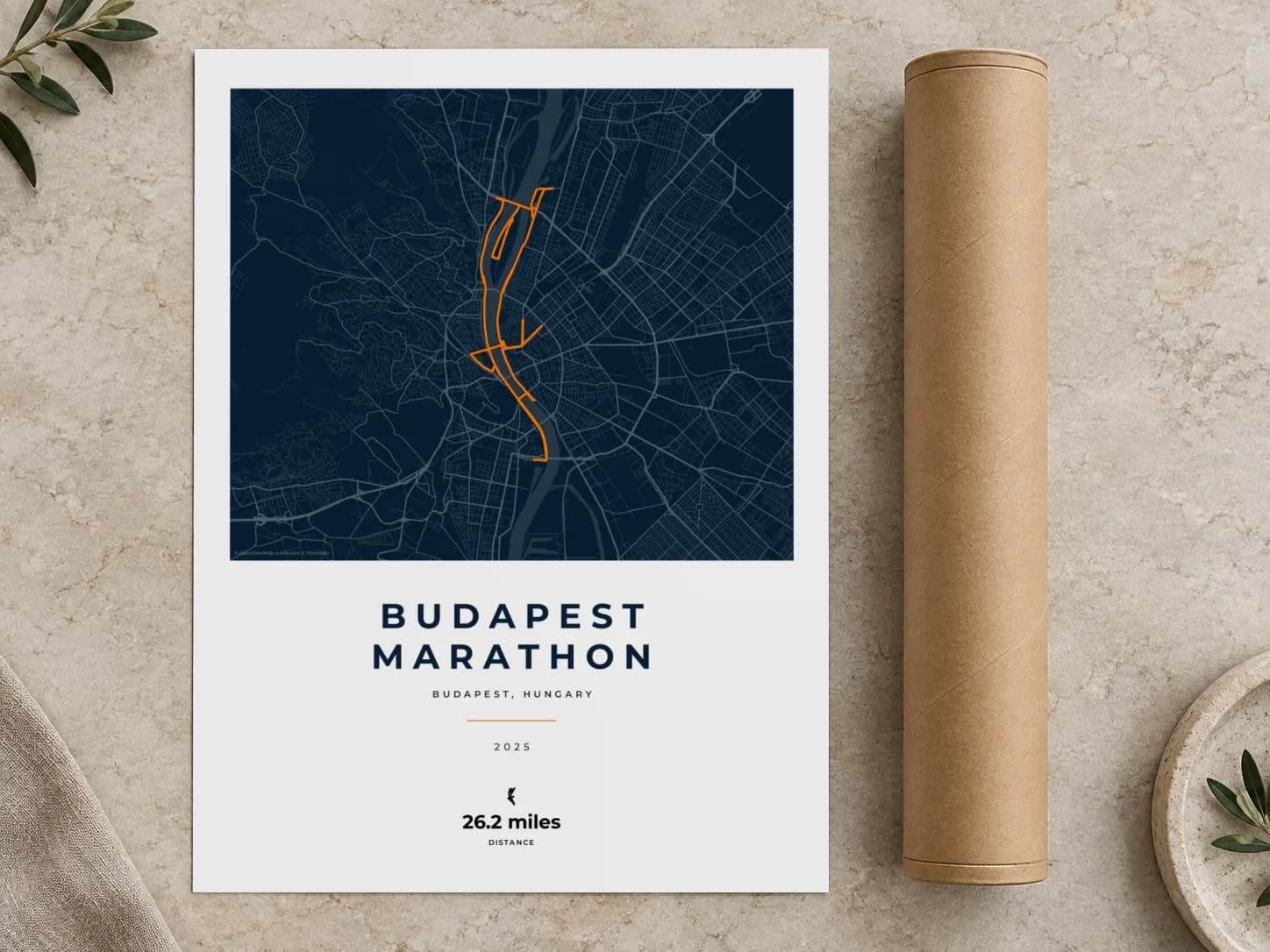 Cardboard postal tube beside a flat Budapest Marathon route print