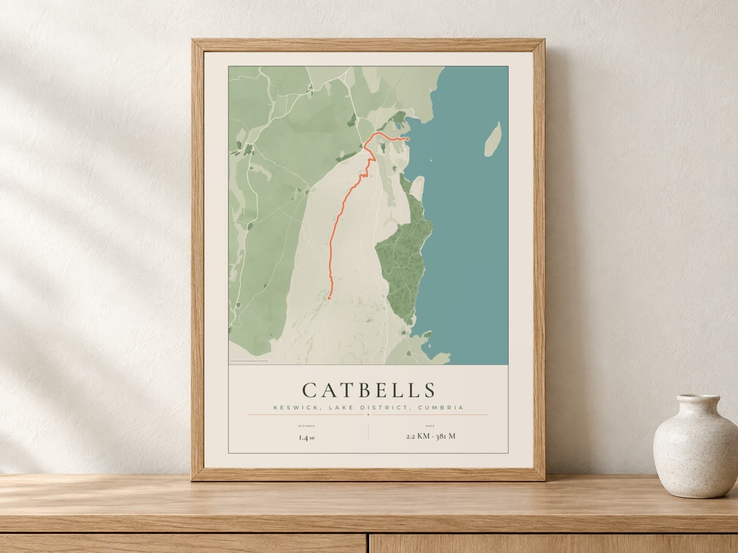 Catbells Parkland route print in a light oak frame on a console