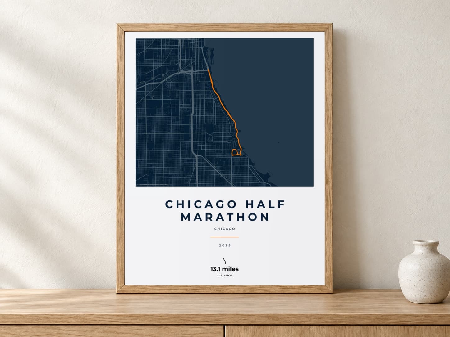 Chicago Half Marathon 2025 Race Blueprint route print in a light oak frame on a console