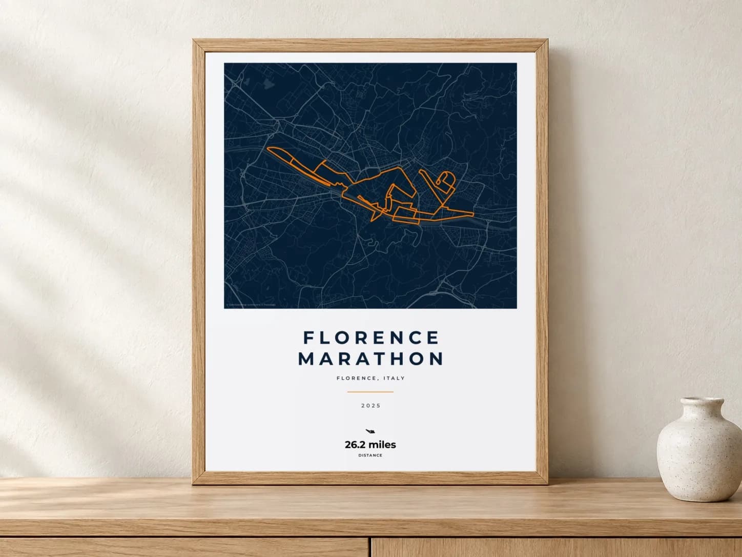 Florence Marathon 2025 Race Blueprint route print in a light oak frame on a console