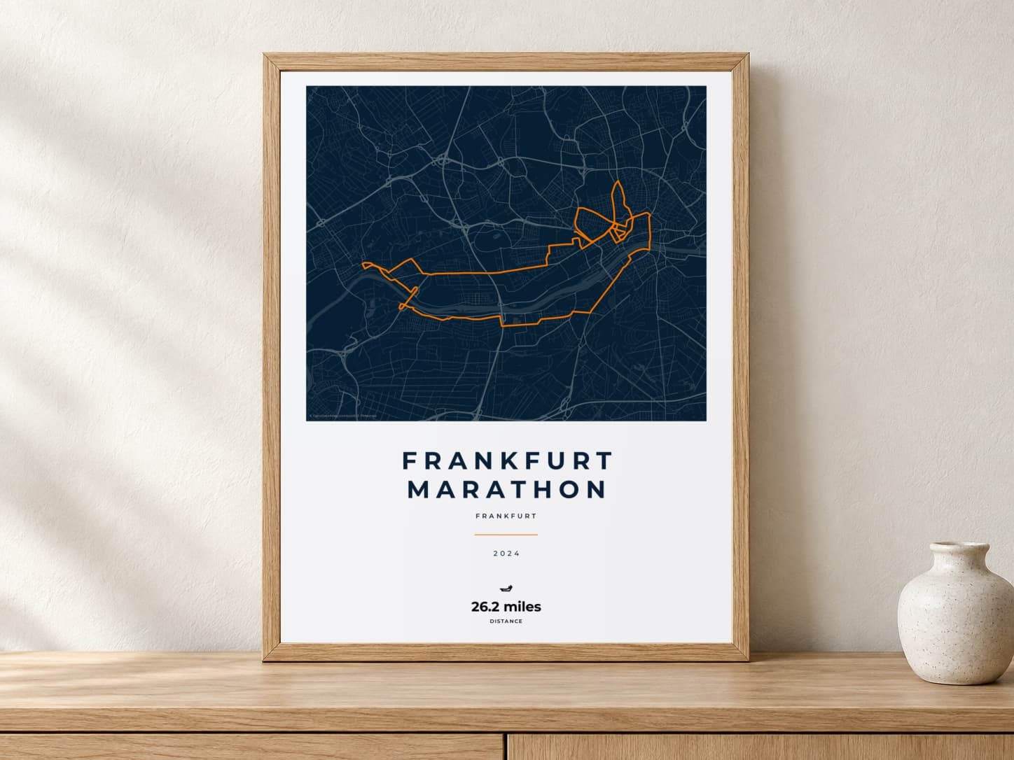 Frankfurt Marathon 2024 Race Blueprint route print in a light oak frame on a console