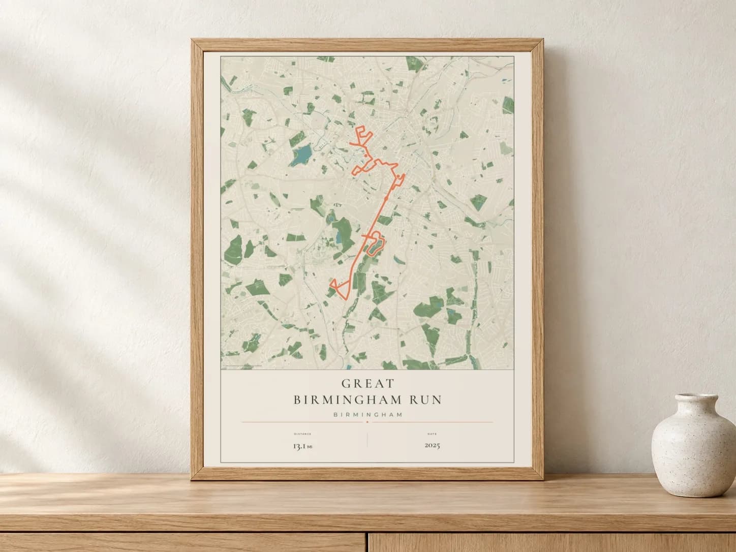 Great Birmingham Run 2025 Parkland route print in a light oak frame on a console