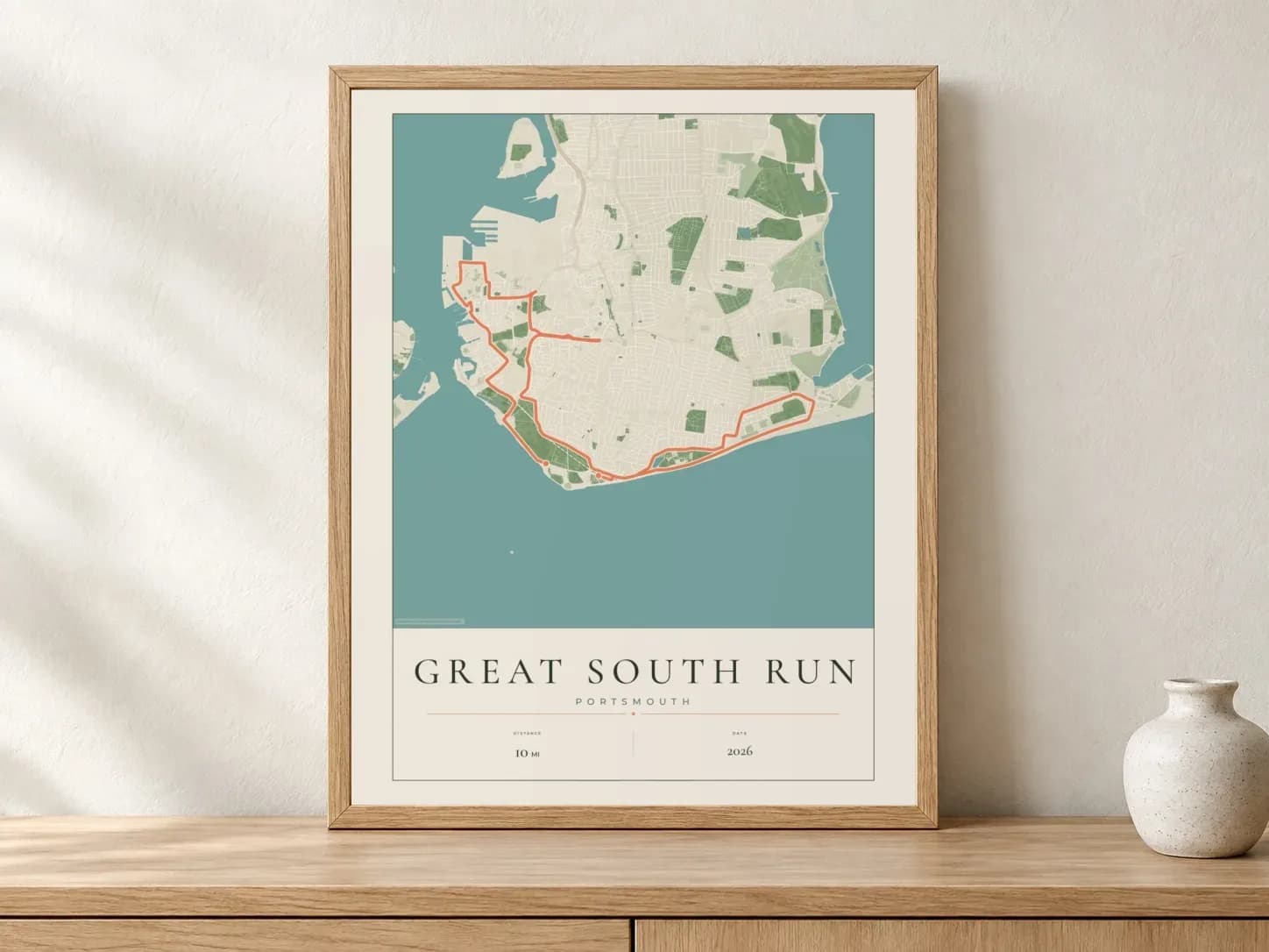 Great South Run Parkland route print in a light oak frame on a console