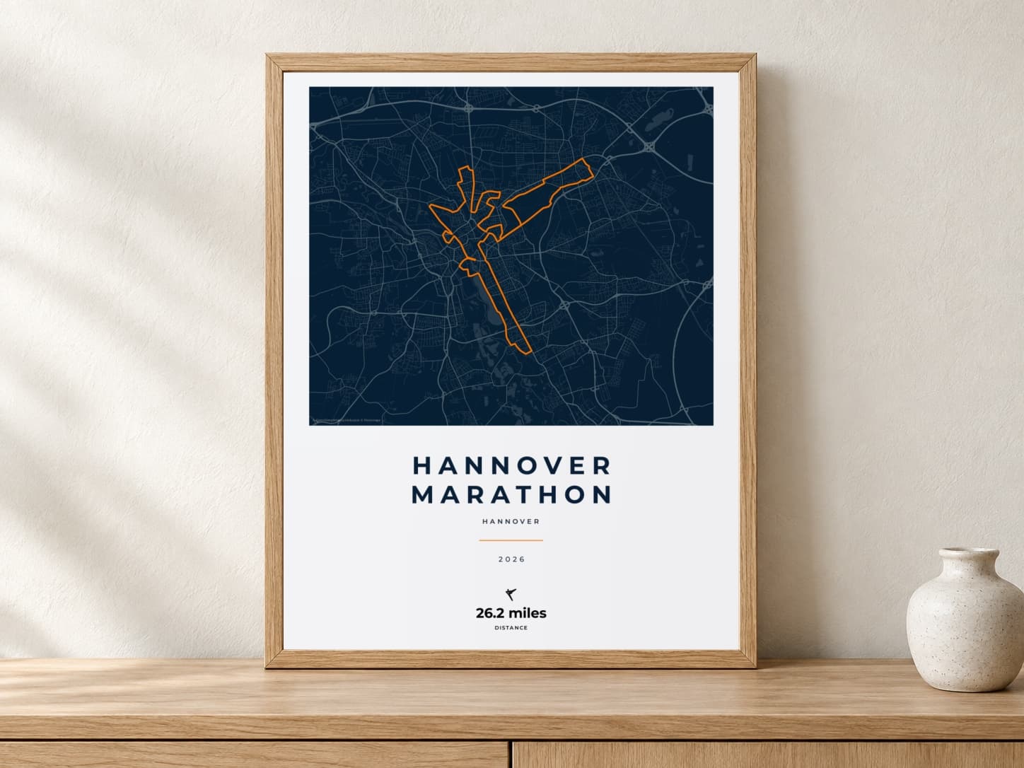 Hannover Marathon 2026 Race Blueprint route print in a light oak frame on a console