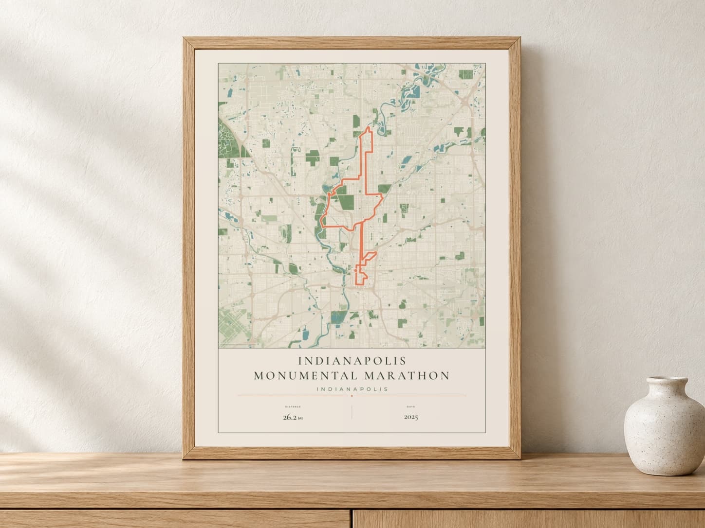 Indianapolis Monumental Marathon 2025 Parkland route print in a light oak frame on a console