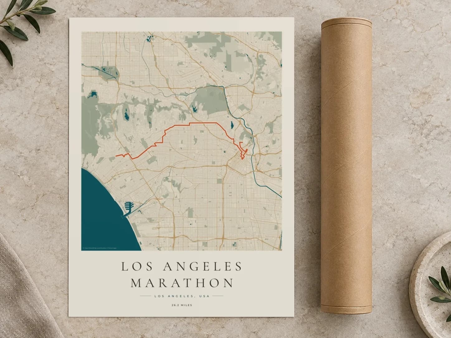Cardboard postal tube beside a flat Los Angeles Marathon route print
