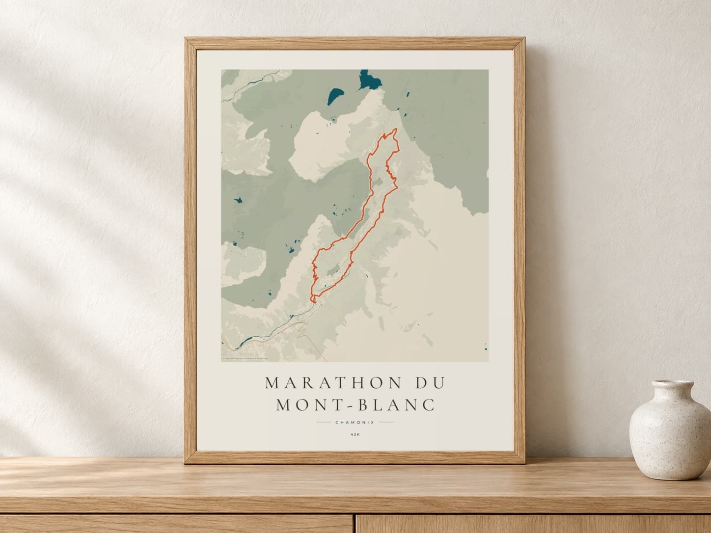 Marathon du Mont-Blanc 2026 Coastal Atlas route print in a light oak frame on a console