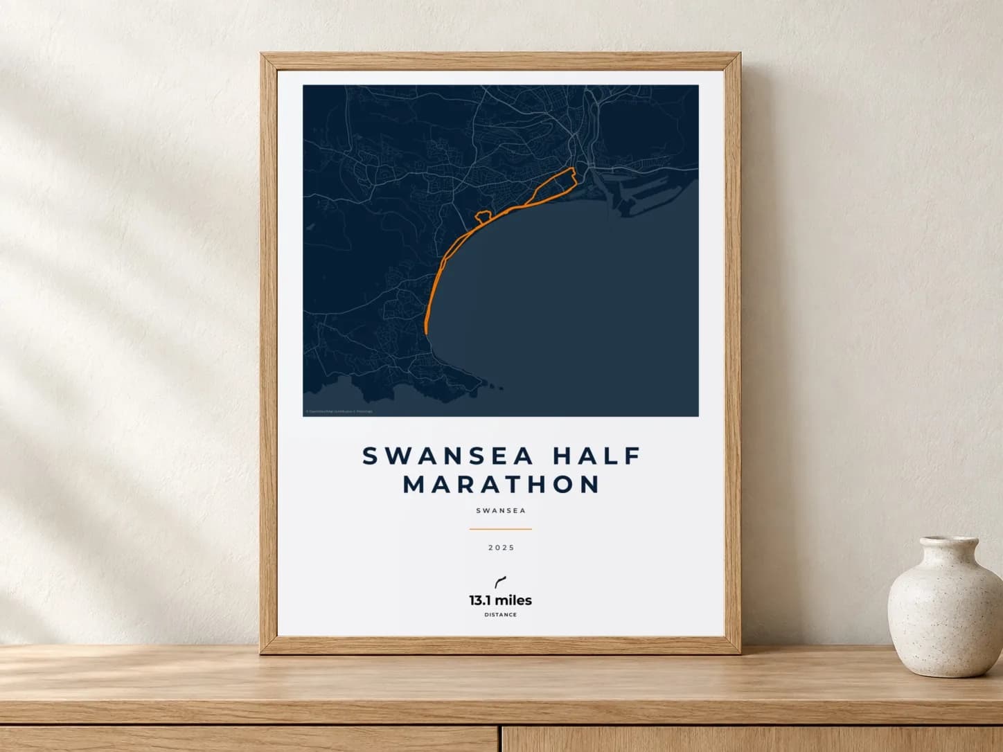 Swansea Half Marathon 2025 Race Blueprint route print in a light oak frame on a console