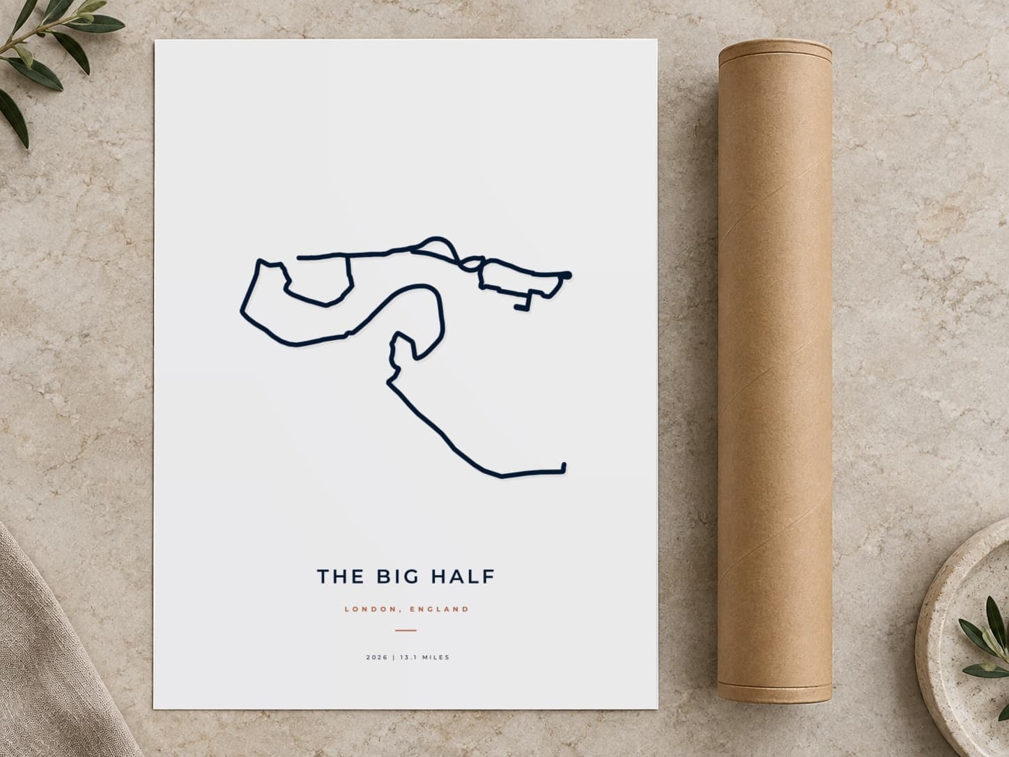 Cardboard postal tube beside a flat The Big Half route print