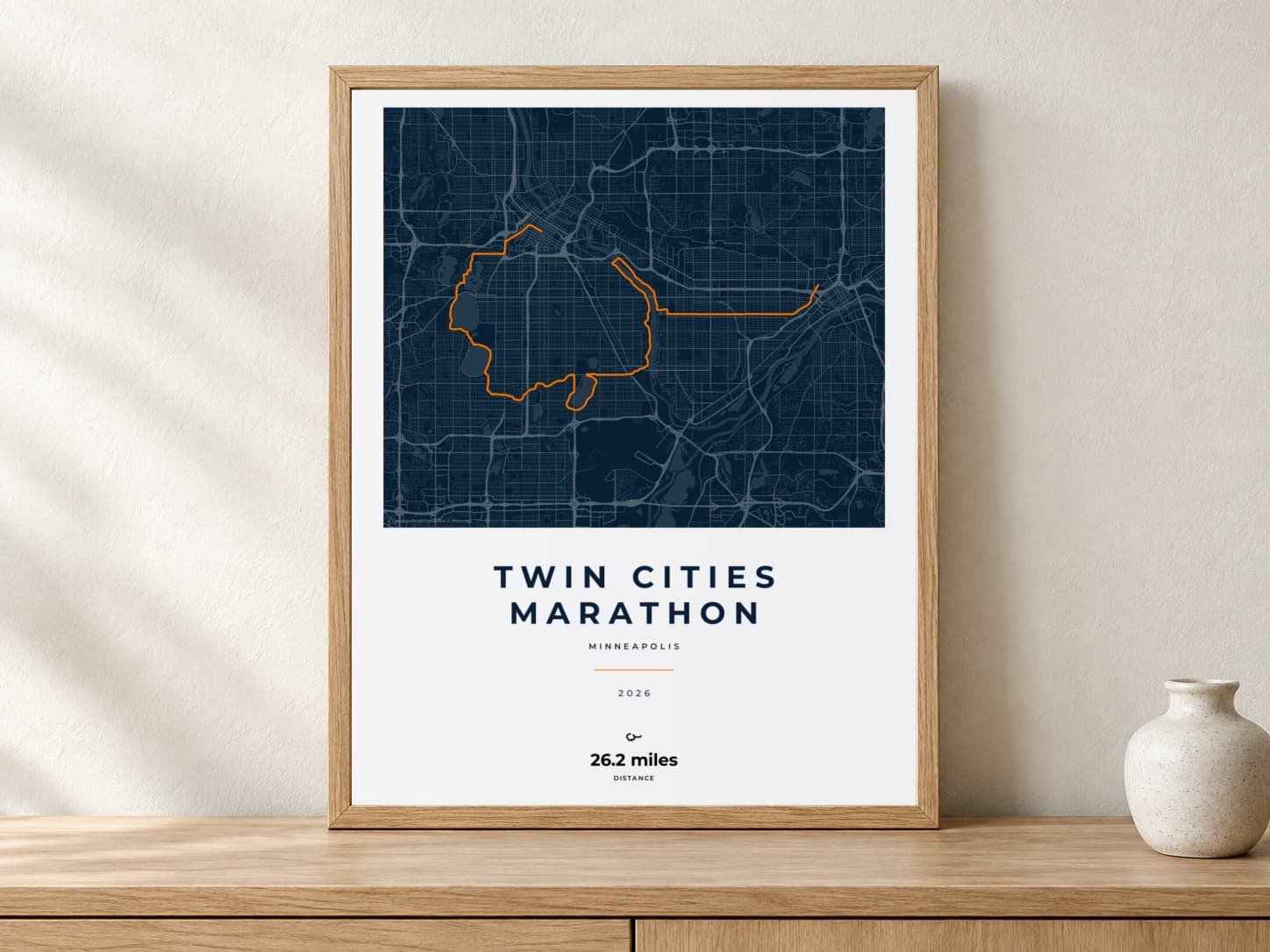 Twin Cities Marathon 2026 Race Blueprint route print in a light oak frame on a console