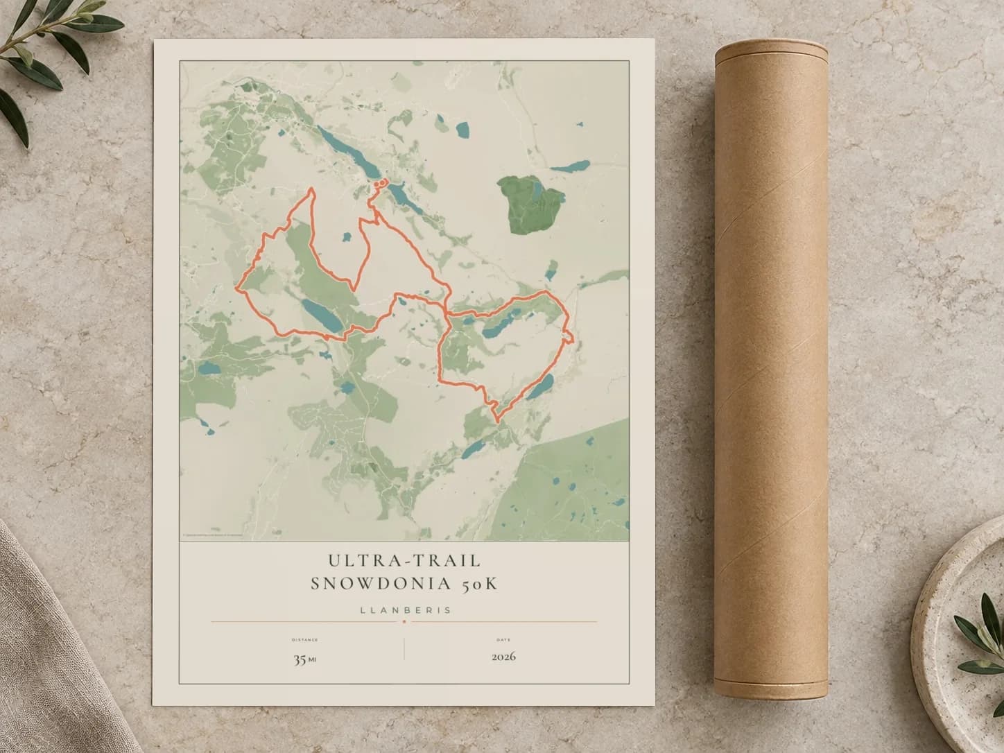 Cardboard postal tube beside a flat Ultra-Trail Snowdonia 50K route print