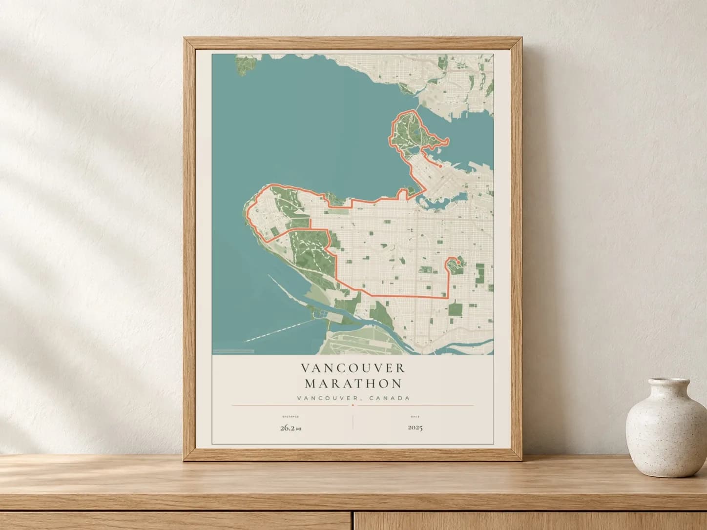 Vancouver Marathon 2025 Parkland route print in a light oak frame on a console