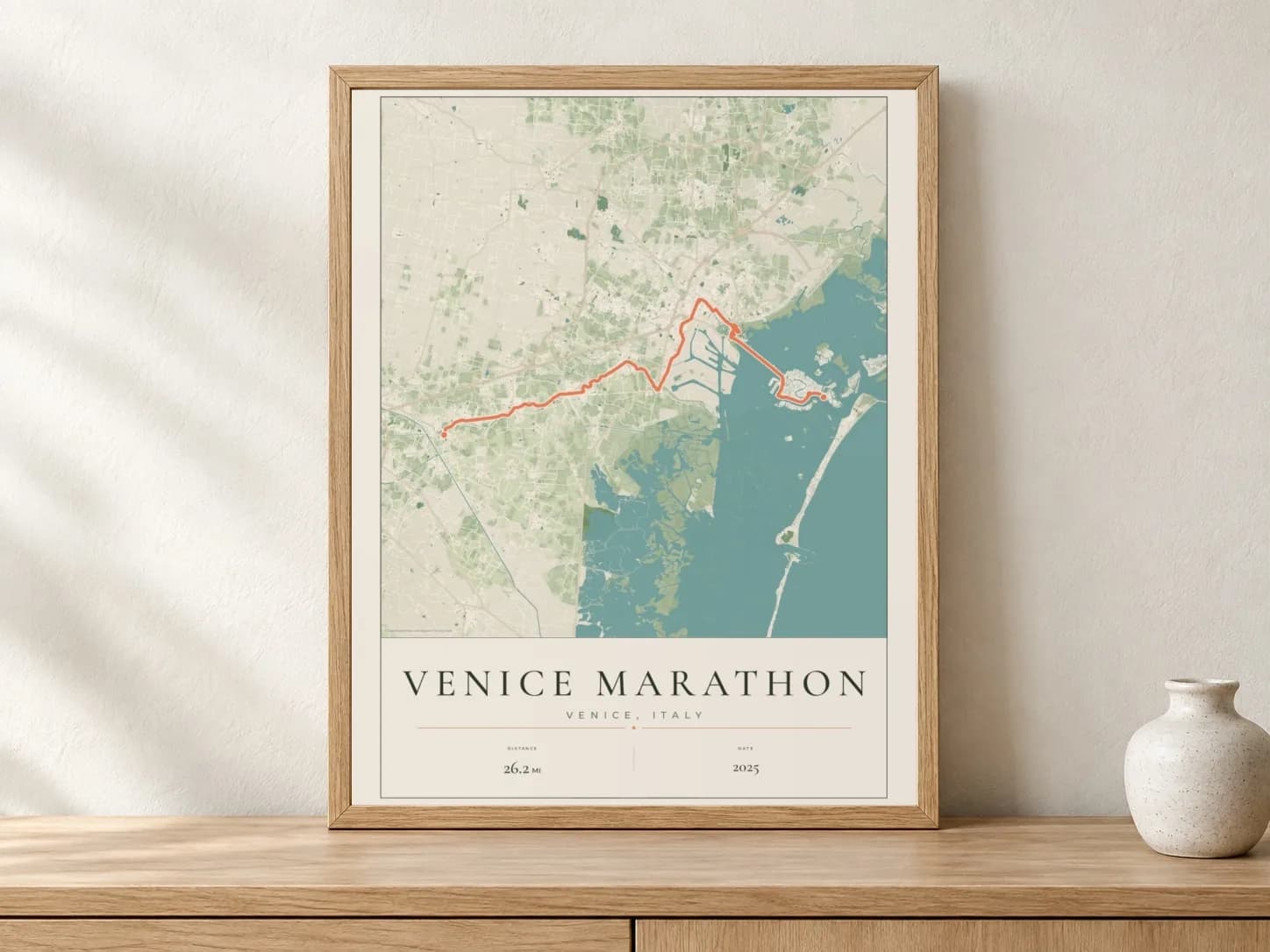 Venice Marathon 2025 Parkland route print in a light oak frame on a console