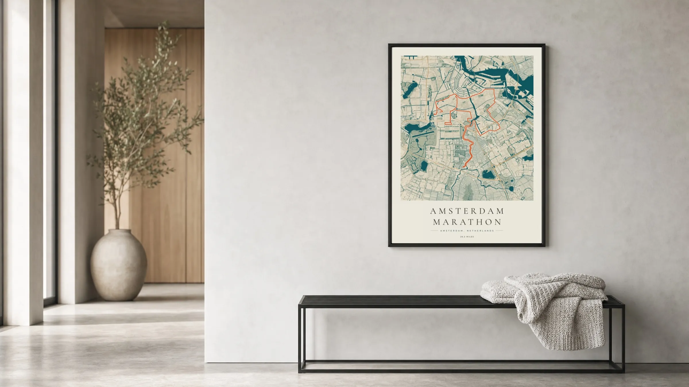 Amsterdam Marathon 2026 Coastal Atlas route print in a black frame in a bright hallway