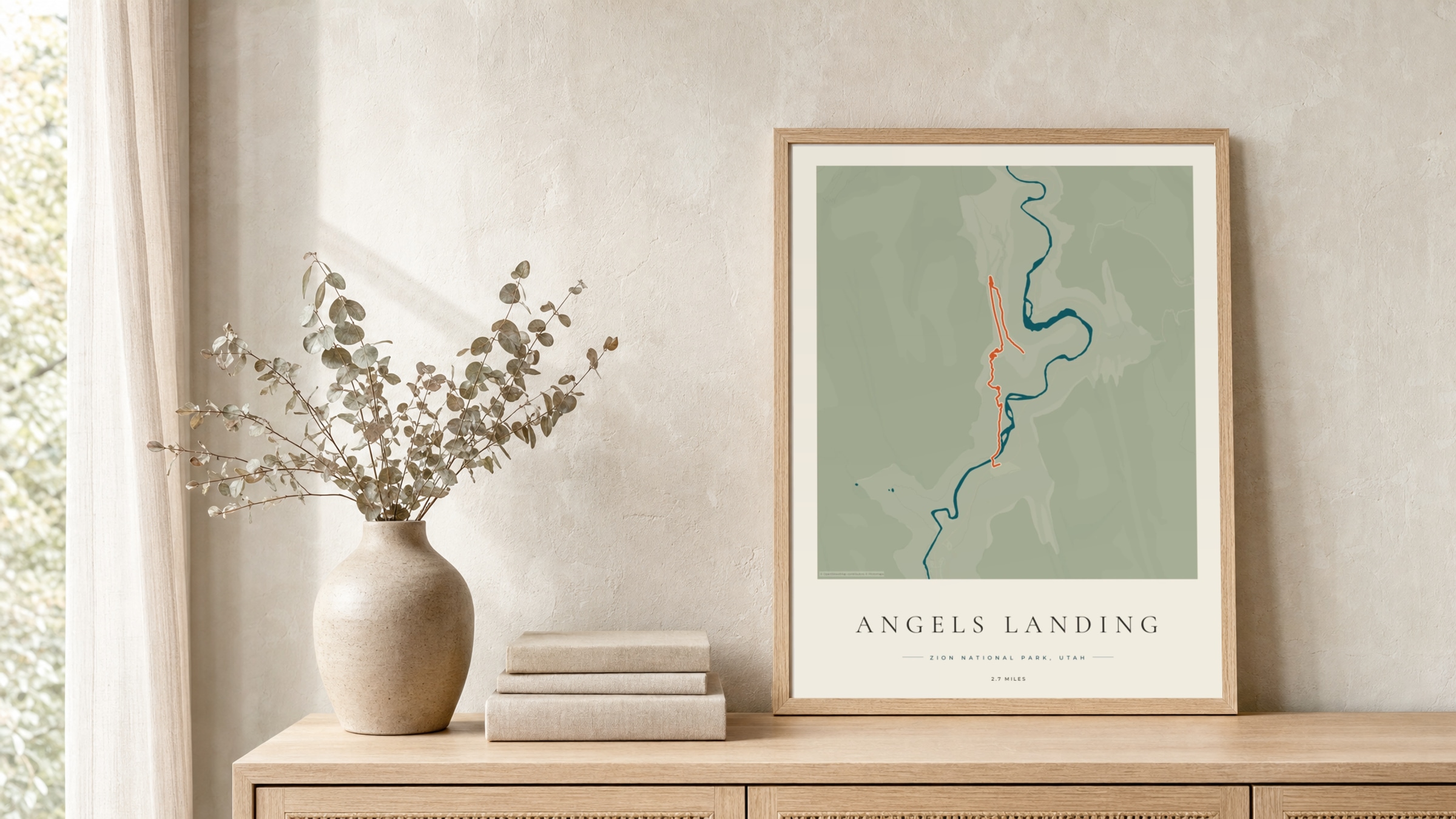 Angels Landing Coastal Atlas route print in a light oak frame on a rattan console