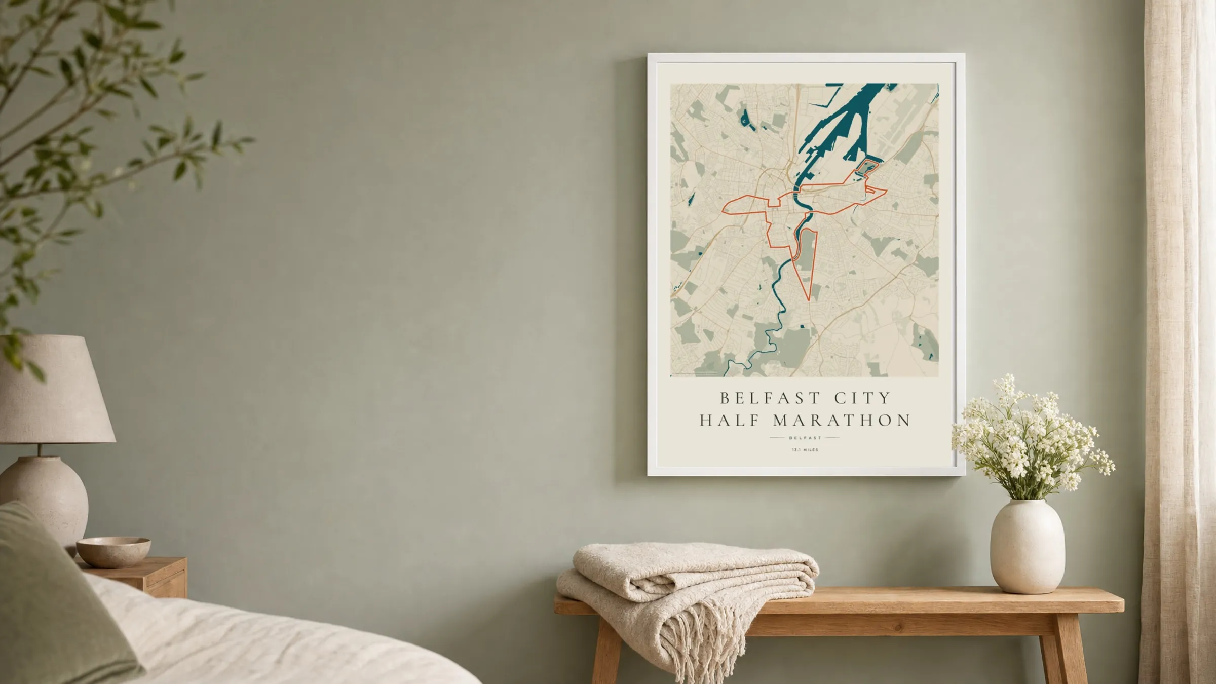 Belfast City Half Marathon 2026 Coastal Atlas route print in a white frame on a sage bedroom wall